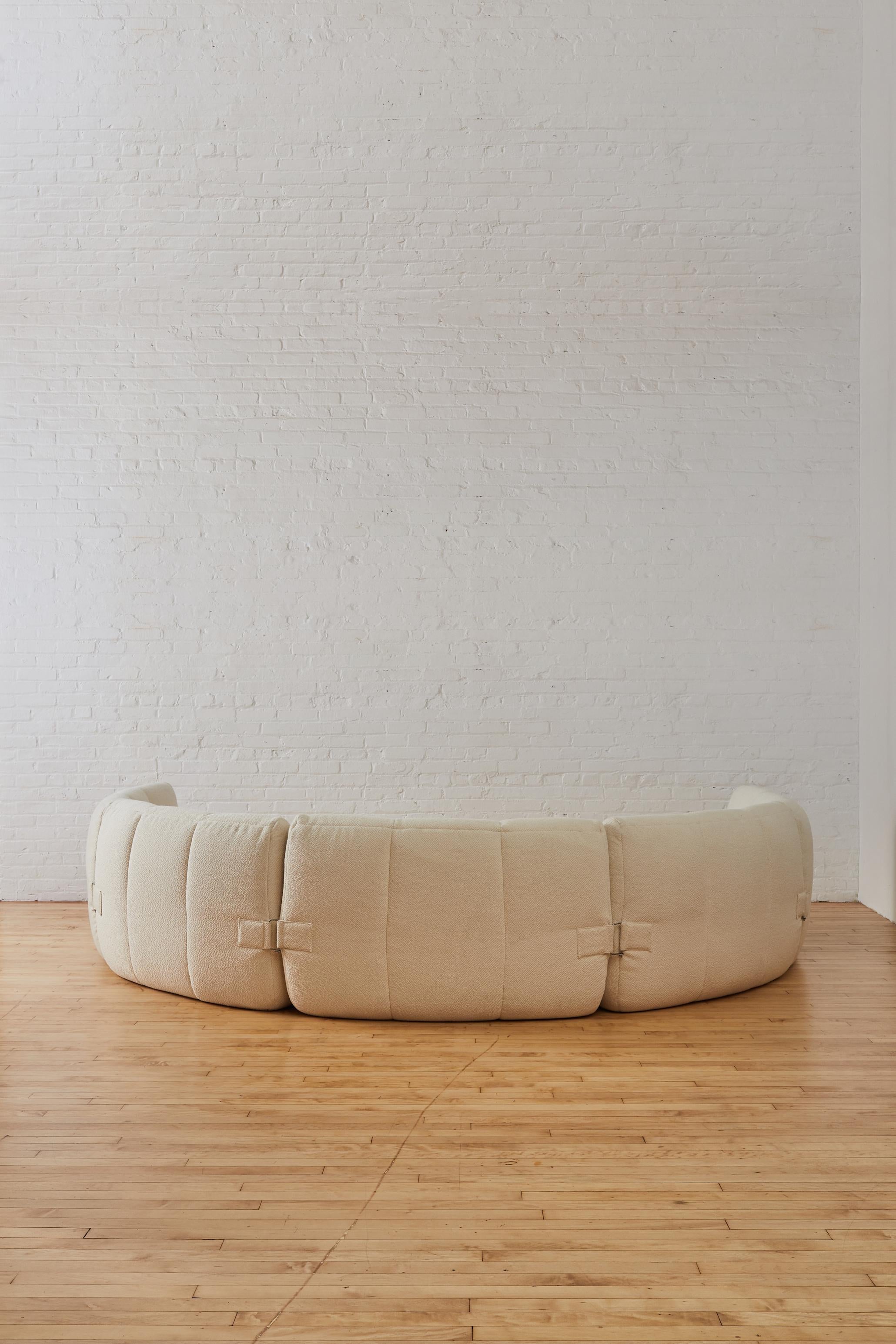A rare Michel Ducaroy for Ligne Roset Upholstered Gilda Modular Sofa in cream boucle. The sofa consists of six elements connected with metal buckles to hold them in place. Each piece can stand alone by separating or can be placed together.