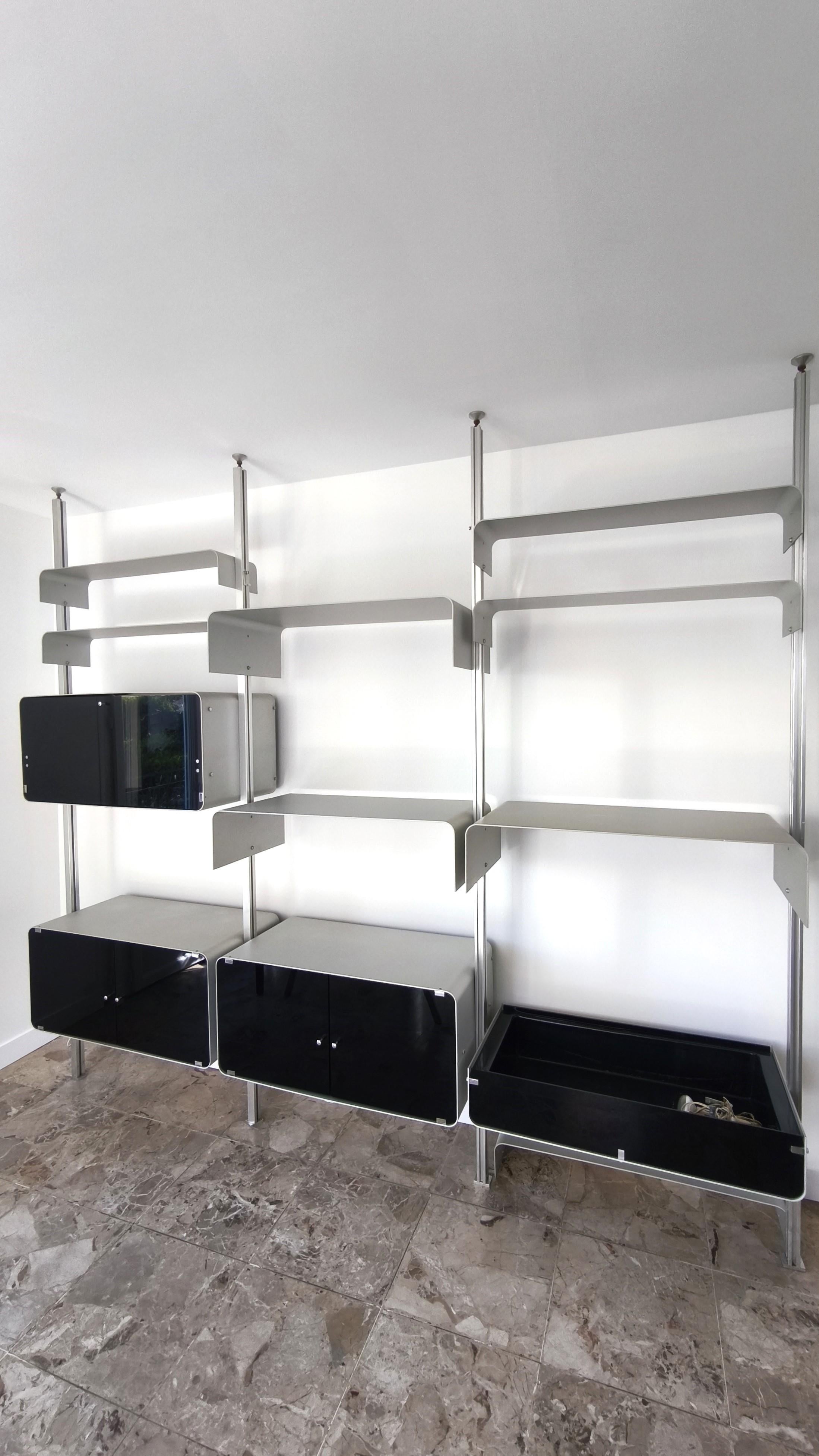 Very rare Michel Ducaroy modular bookcase wall unit, aluminum boxes and shelves, 70s.
.
3 columns.
.
Aluminum units and shelves mounted on aluminum profiles.

The units are closed by black tinted glass doors.
.
A screw system allows the uprights to