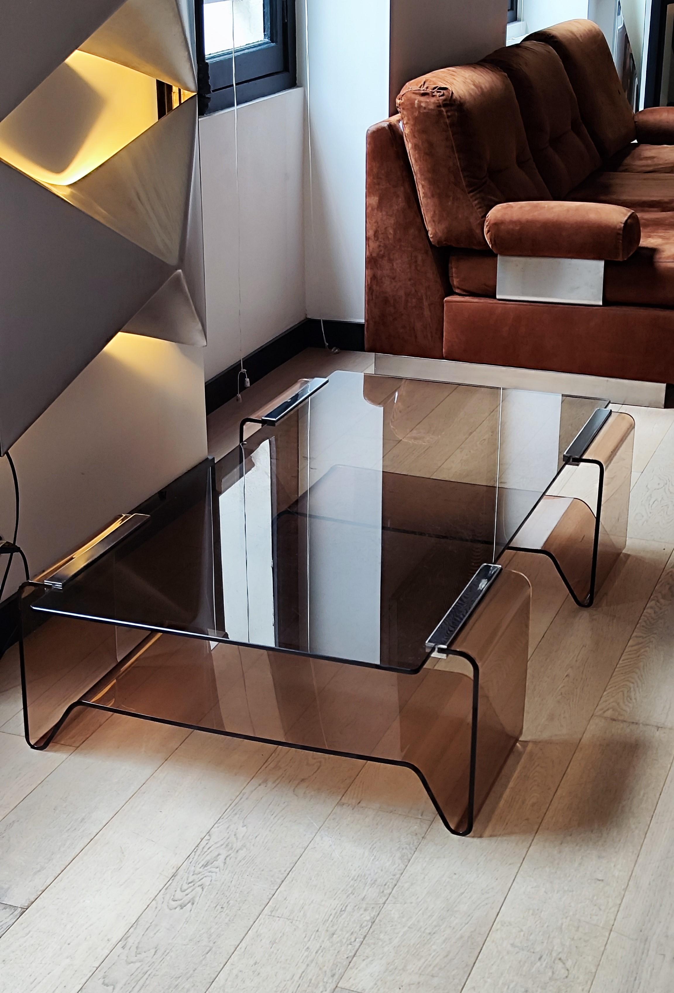 Delightful, minimalist and large coffee table by designer Michel Dumas dating from the 1970s. 
.
Plexiglas base supporting a smoked glass top with chrome steel sides.
.
Dimensions : 
Length : 130 cm
Width : 74 cm
Height : 30 cm
.
Superb condition
