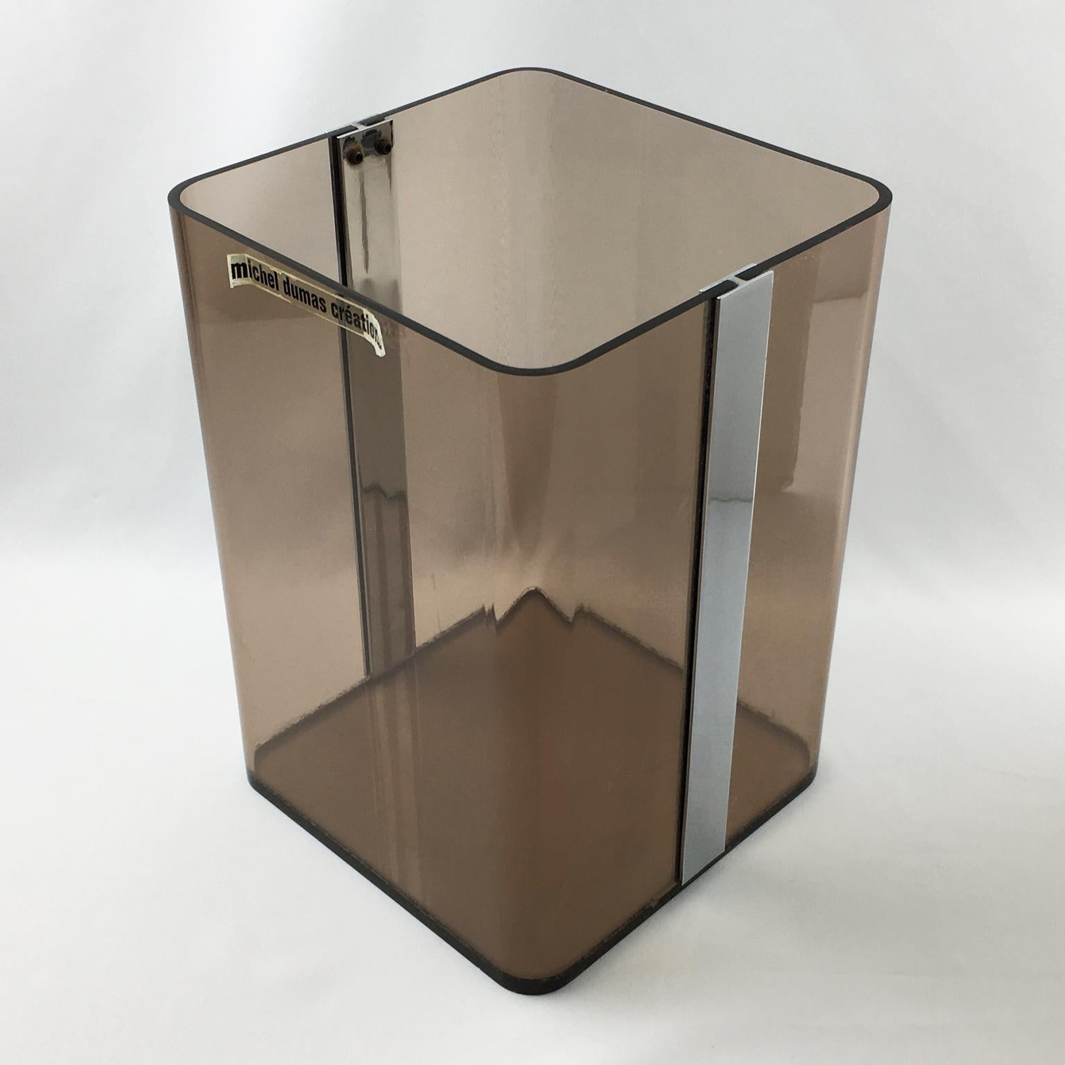 Elegant Lucite paper waste basket designed for Roche Bobois by Michel Dumas Creations in 1970s. Geometric tall shape with chrome accent and transparent gray smoke Lucite. Great accessory for any modern interior, office or bathroom. Still has its