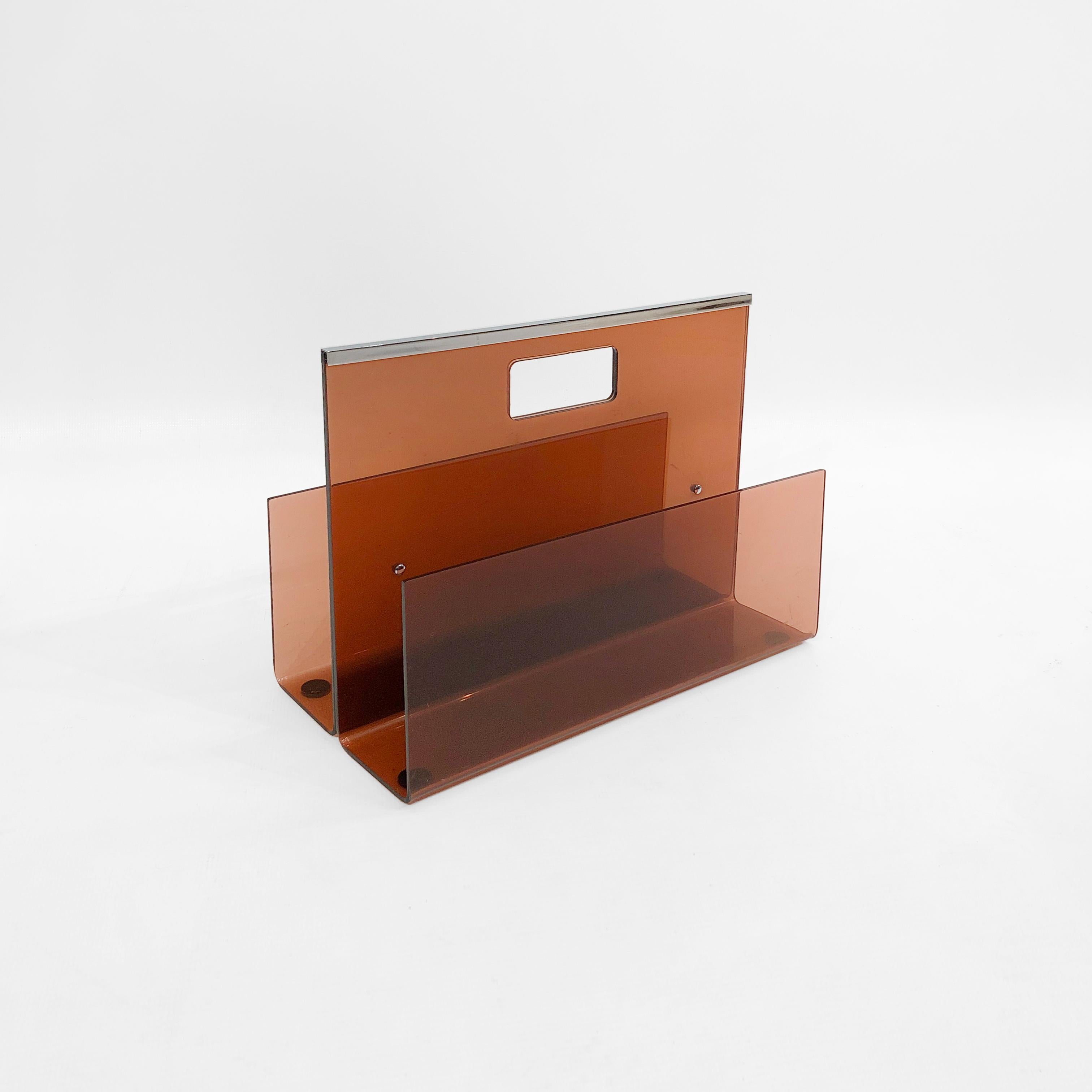 An impressive smoked acrylic magazine rack, coloured a translucent burnt orange, from acclaimed French designer Michel Dumas for Roche Bobois. 

Dumas worked almost exclusively in plexiglas, and here we find sleek modernist straight lines