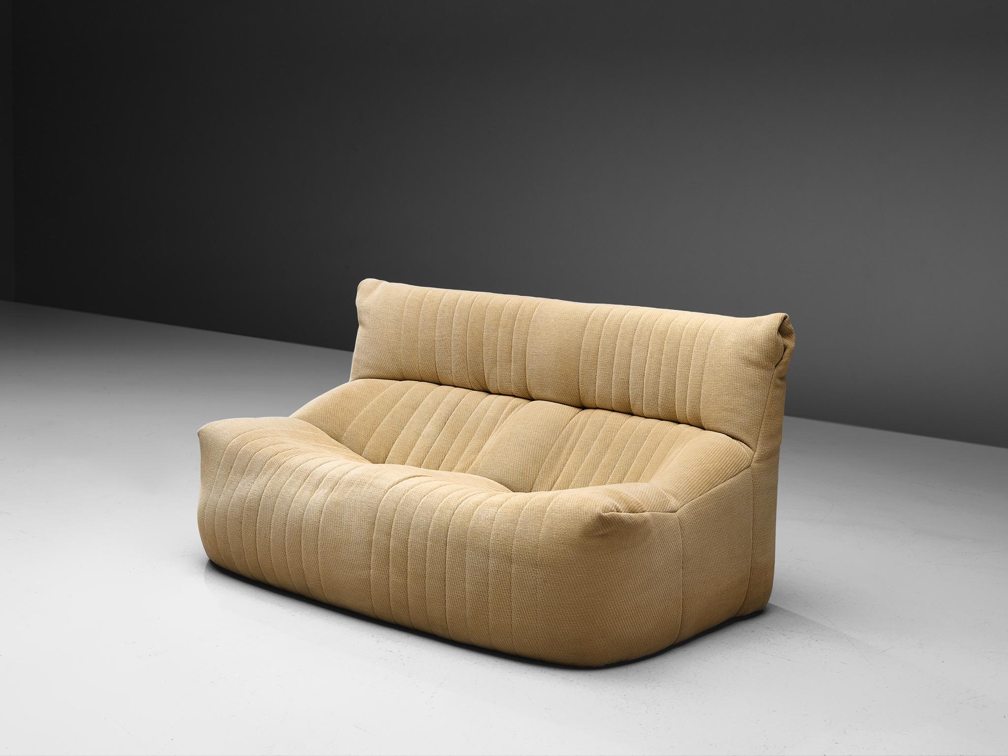 Ligne Roset, sofa, fabric, France, circa 1973.

This comfortable and grand two-seater sofa is manufacture by Ligne Roset. This model features a solid base with a rounded, bulky seat and a high back. The fabric is tufted with vertical lines. A highly