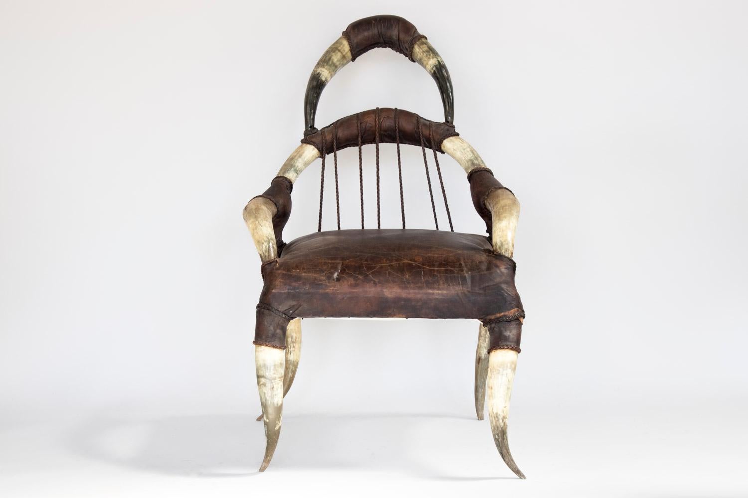 Michel Haillard, in the style of.
Pair of armchairs with head support, armrests and legs in buffalo horn. Dark brown leather seat. Back made of seven leather braids joining the backset crosspiece and the seat. Joints between armrests and back, the