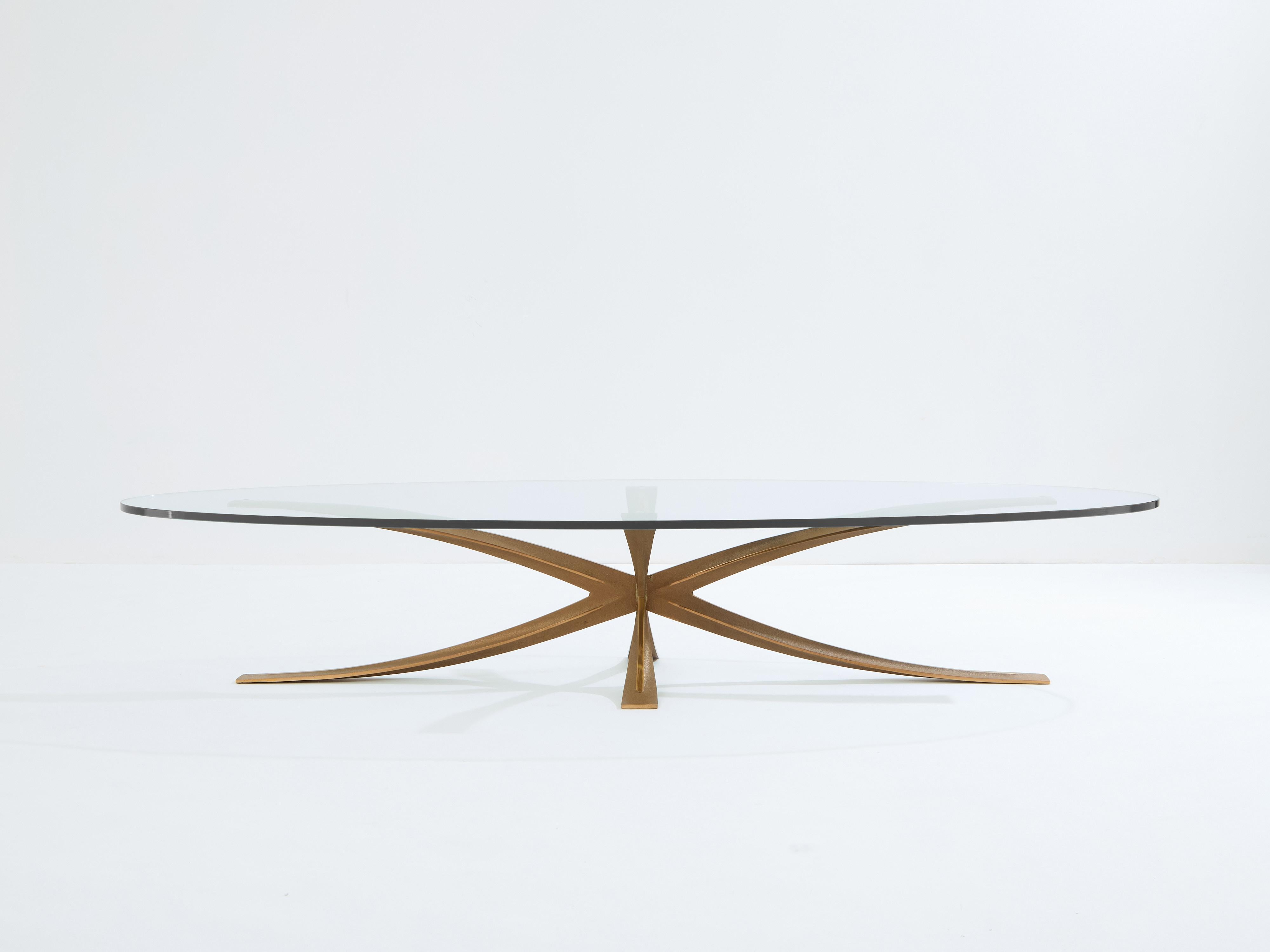 Magnifique table basse en bronze français conçue et produite par Michel Mangematin en 1962. La table présente une grande forme d'étoile en bronze composée de deux formes en X. Le pied en bronze présente des bords polis et une finition en bronze