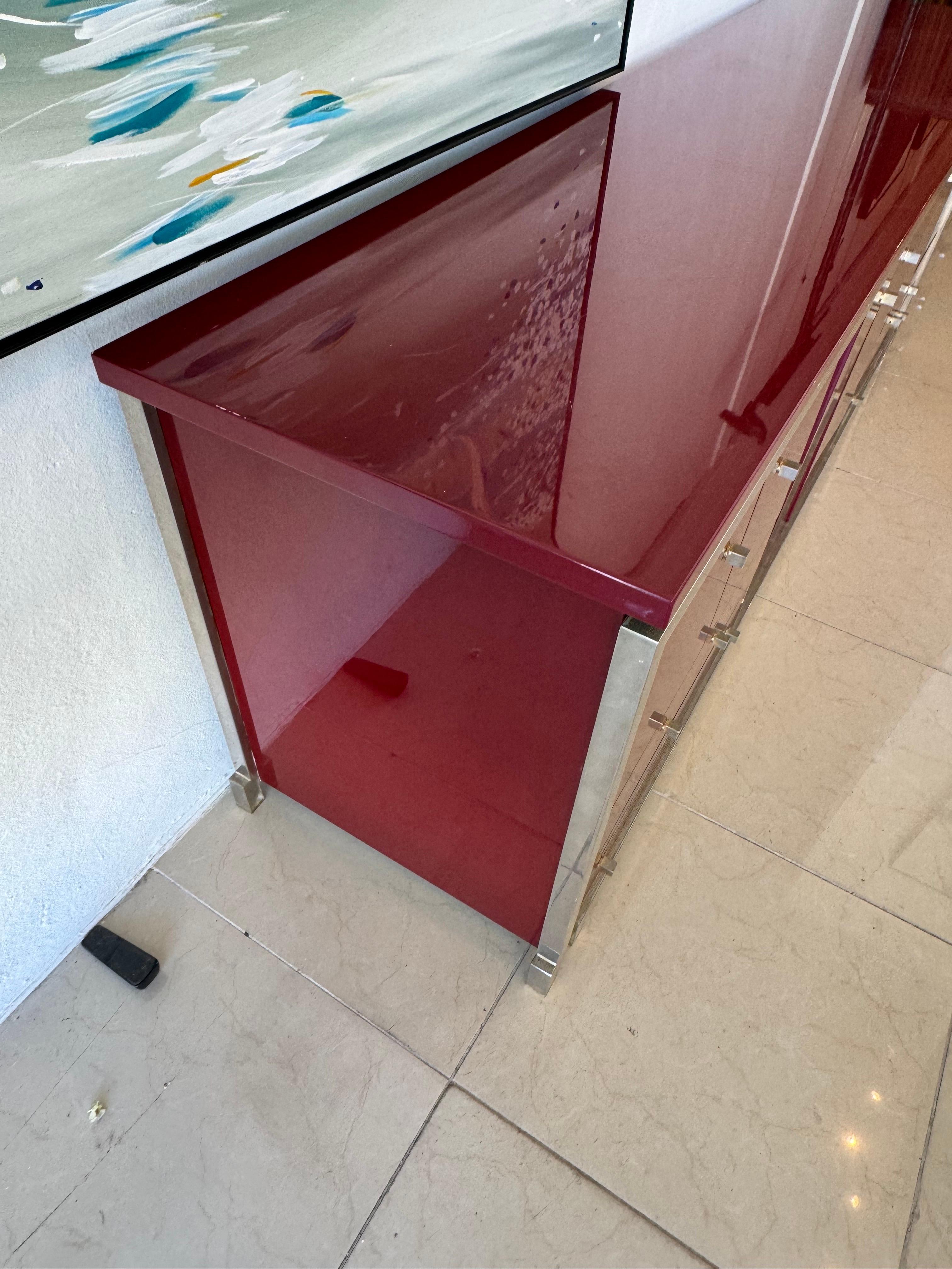 Nice sideboard by Michel Pigneres,  The finish is original lacquered wood. Deep maroon color. The metal is silver with patina. There are some small scratches on the surface as to be expected in a piece this old. 