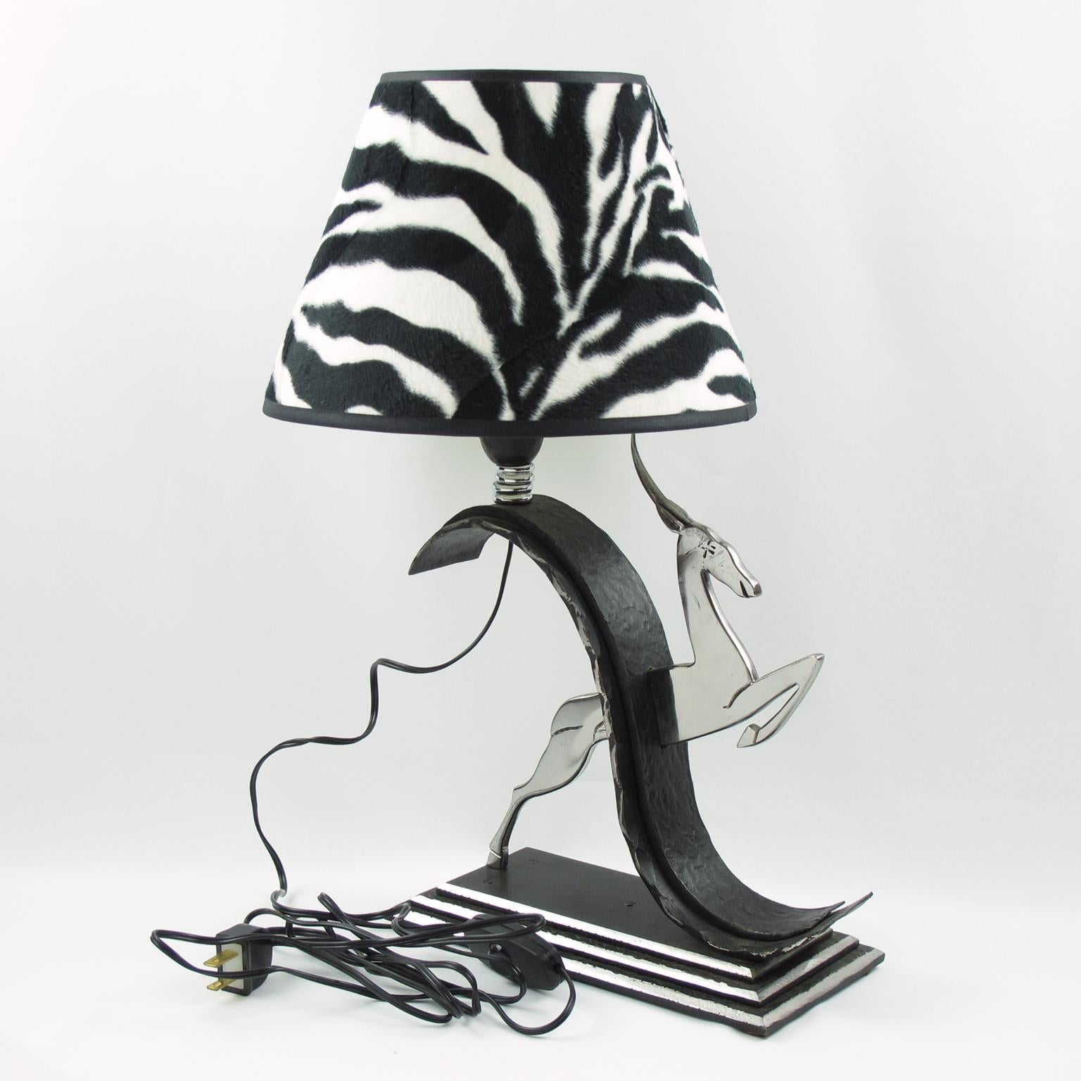 This exquisite Michel Zadounaisky Art Deco antelope wrought iron and chrome table lamp is a timeless piece of French design. The classic jumping antelope design is expertly hand-crafted with hammered wrought iron and chrome, mounted on a rectangular