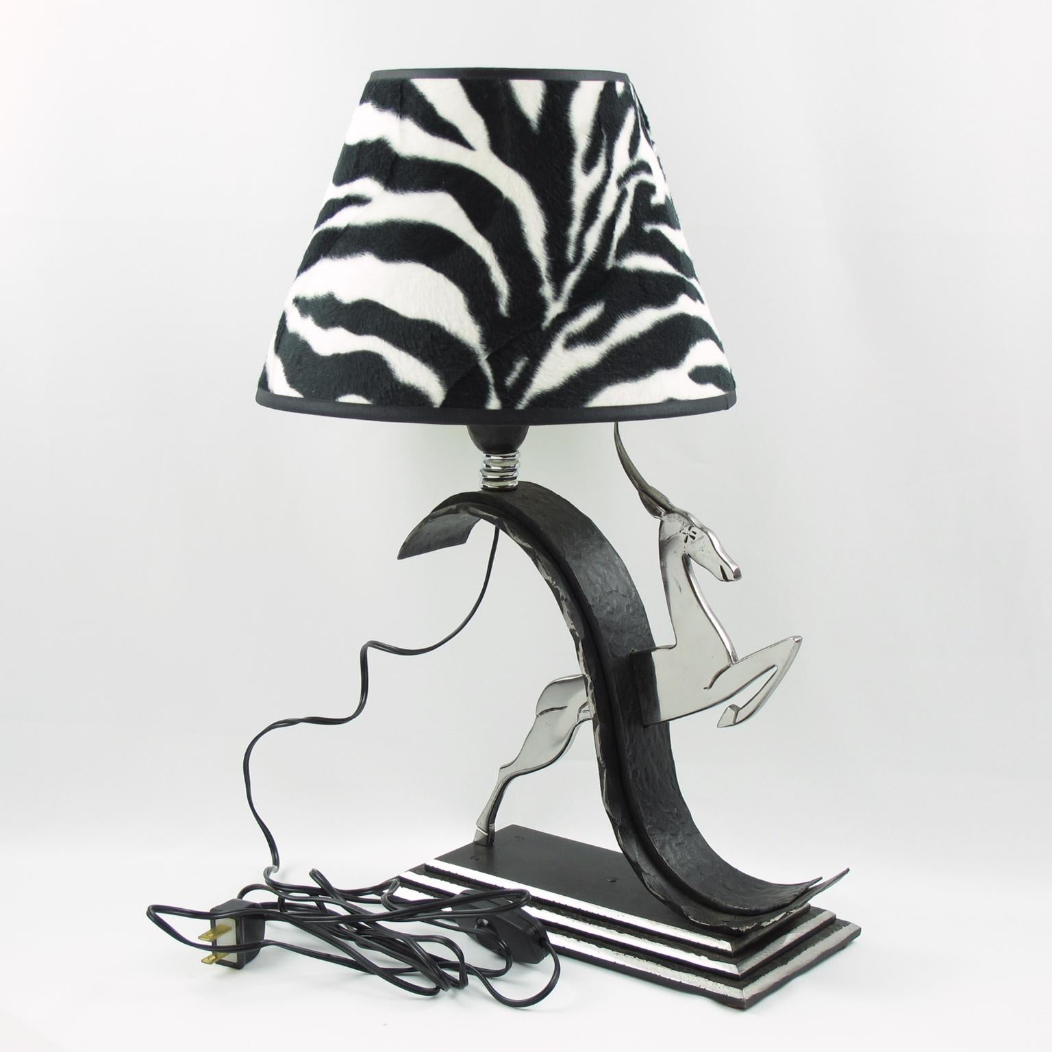 This stunning Art Deco wrought iron and chrome table lamp is a timeless piece of French mastery and was designed by renowned French metalwork artist Michel Zadounaisky. The classic jumping antelope decor is expertly crafted with hammered wrought