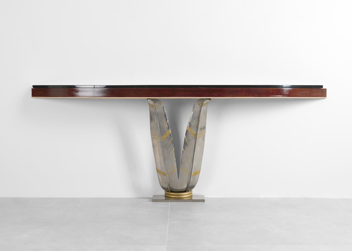 
This wall-mounted console is Michel Zadounaisky's Banana Leaf model. A pair of leaves support a narrow curving top in rosewood and lemon tree, covered by a black opaline glass. The banana leaf pattern is one of Zadounaïsky's favorite motifs, which