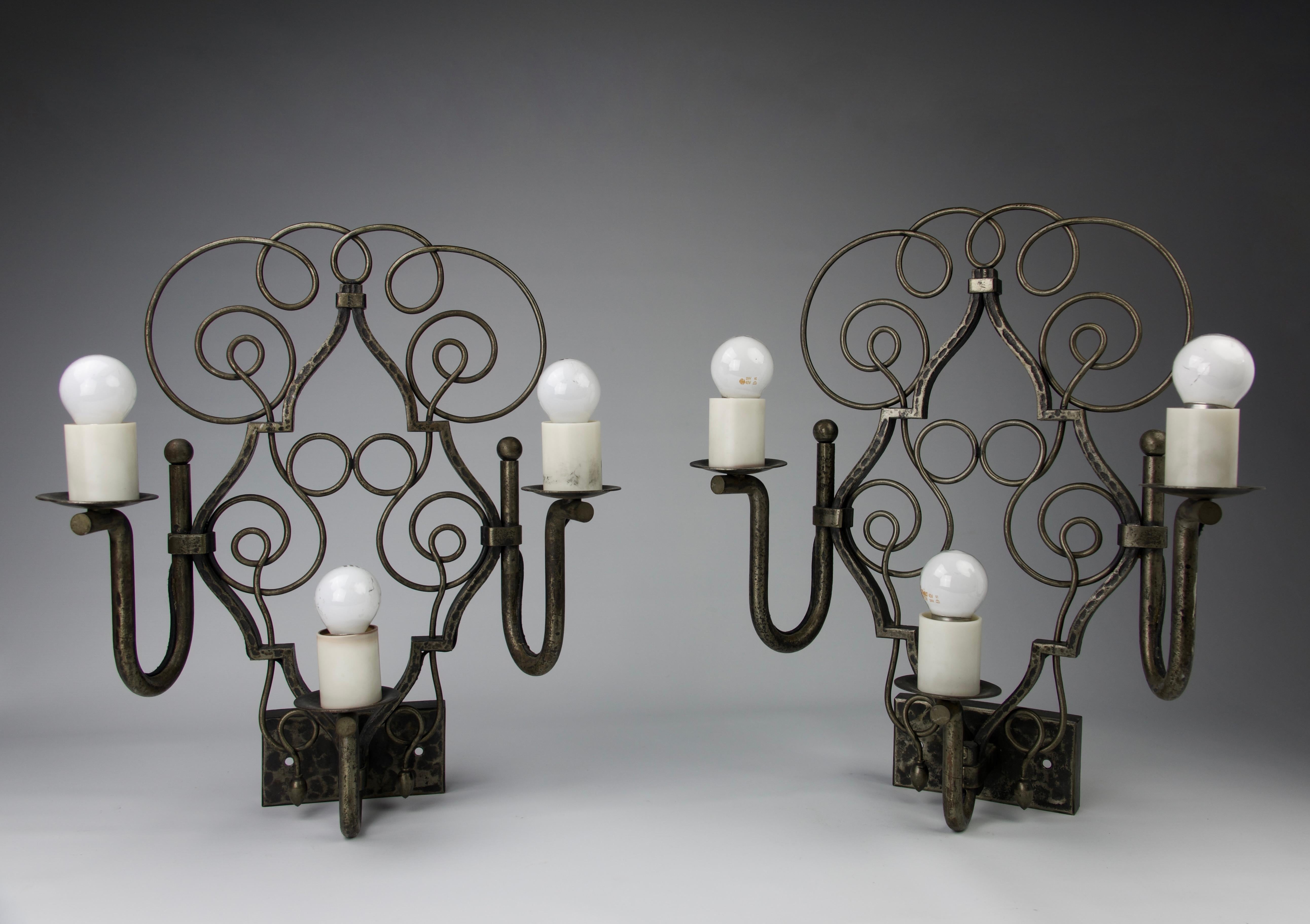 Pair of wrought iron sconces hammered with three stems and body of volutes and interlaces. By Michel ZADOUNAISKY (1903 - 1983). 
Signed in the front.

Very good condition. Slight oxydation.

Height 45 cm - Length 37 cm - Depth 17 cm 

Secure