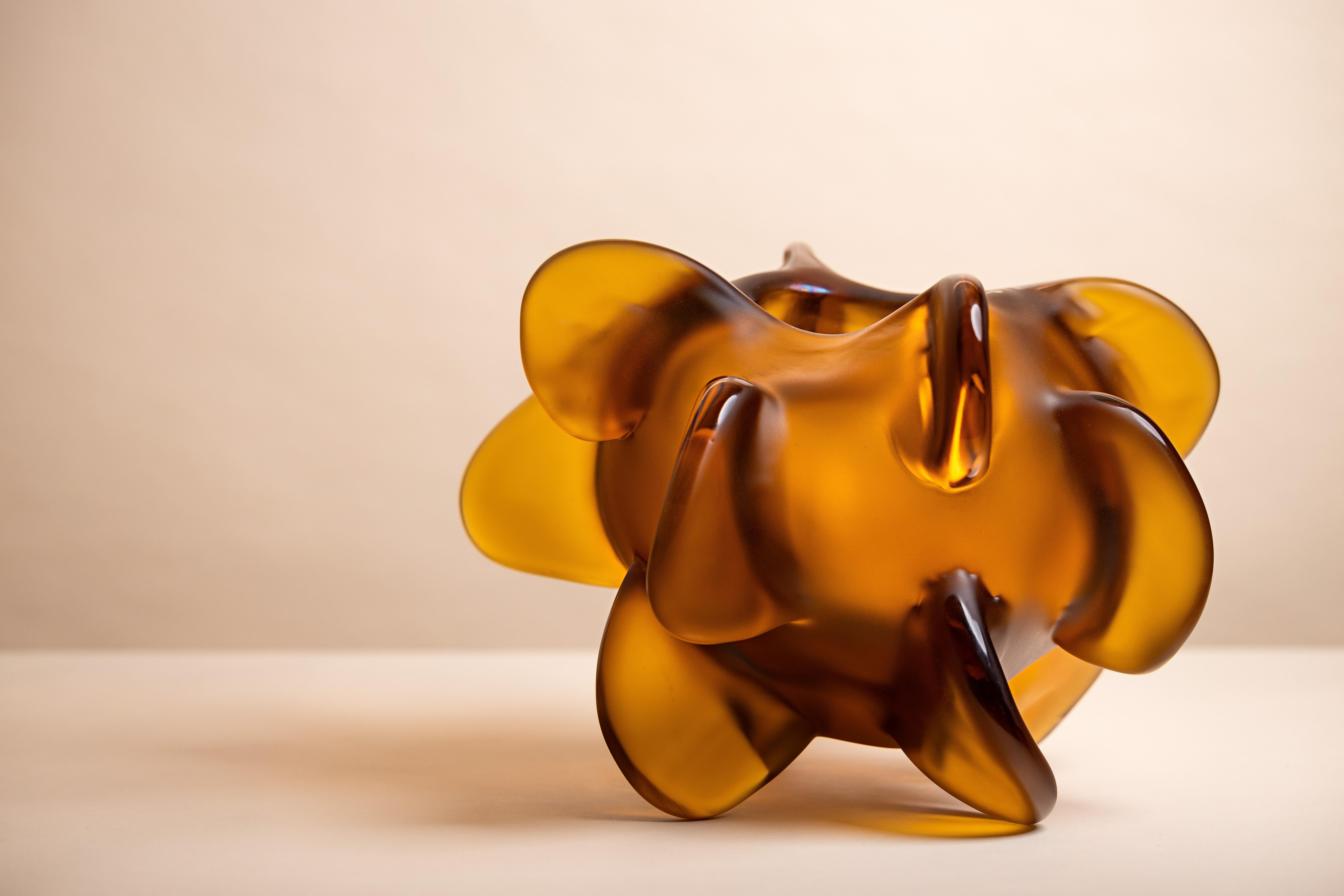 Anémone se compose de pièces uniques en ambre, or, bordeaux foncé et hortensia, exprimant la fascination de Michela Cattai pour la nature dans toutes ses formes et manifestations imprévisibles. Chaque pièce a été fabriquée à Murano, selon la