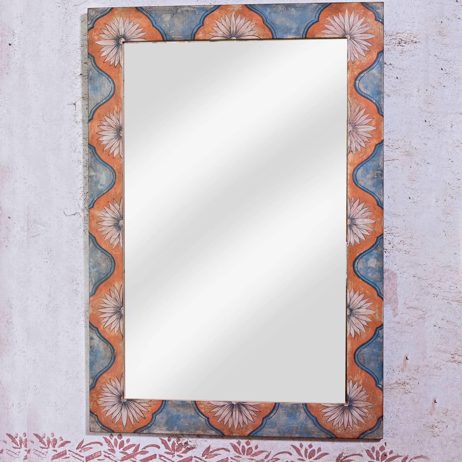 Breathtaking in its simplicity, this large Venetian style mirror is crafted of wood and showcases a hand painted decoration of white flowers in a contoured, orange frame that stand out on a soft sky-blue background. A truly unique and elegant piece,