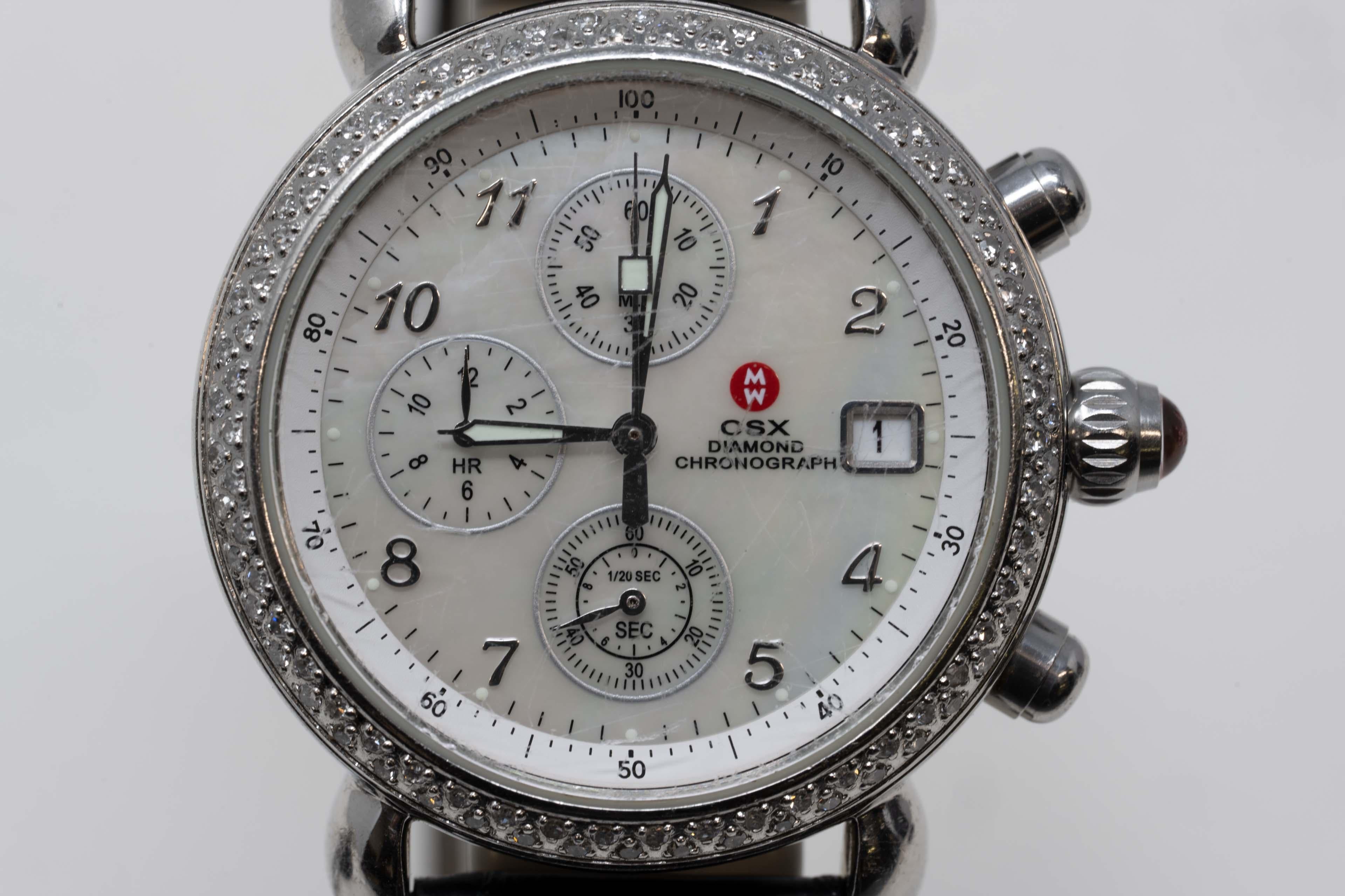 Michele C S X diamond chronograph quartz leather band watch. The watch has a mother-of-pearl tone dial watch with genuine diamond jewels and stainless steel. The strap is leather and equipped with an adjustable buckle clasp.