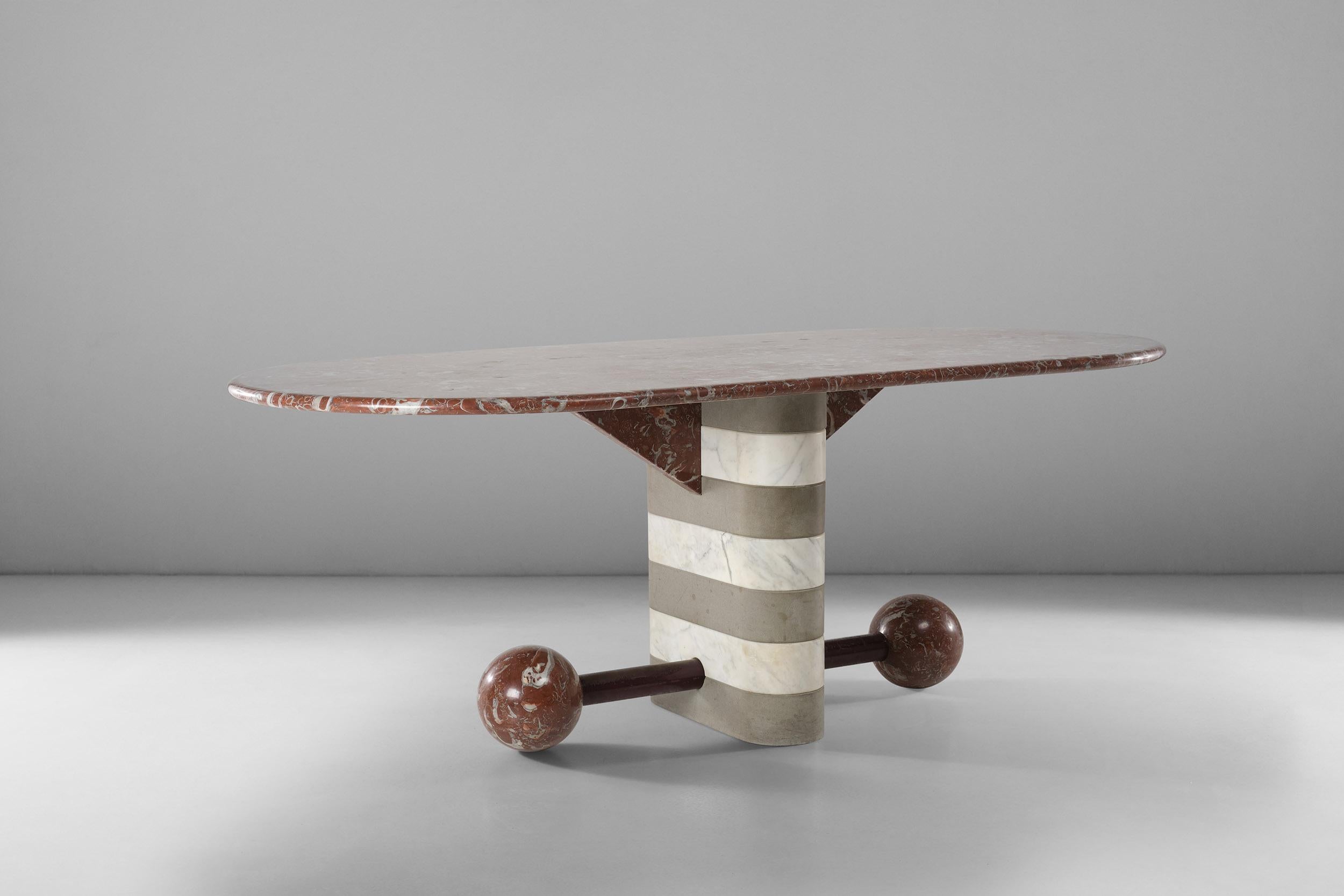 This wonderful table in marble and serena stone was designed by Michele de Lucchi in 1982 for Memphis. Iconic and truly unique in its shapes, this is a exceptional example of postmodern design. Its rounded single leg in a striped pattern of white