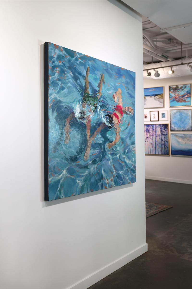 This original coastal figural painting by Michele Poirier-Mozzone features a cool palette and captures a view of two figures swimming in the water from above. One wears a green swim suit, with the other in a vibrant red suit. They swim just beneath