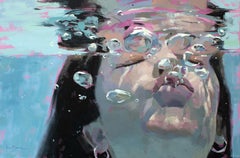 Girl underneath the surface of the water blowing bubbles,