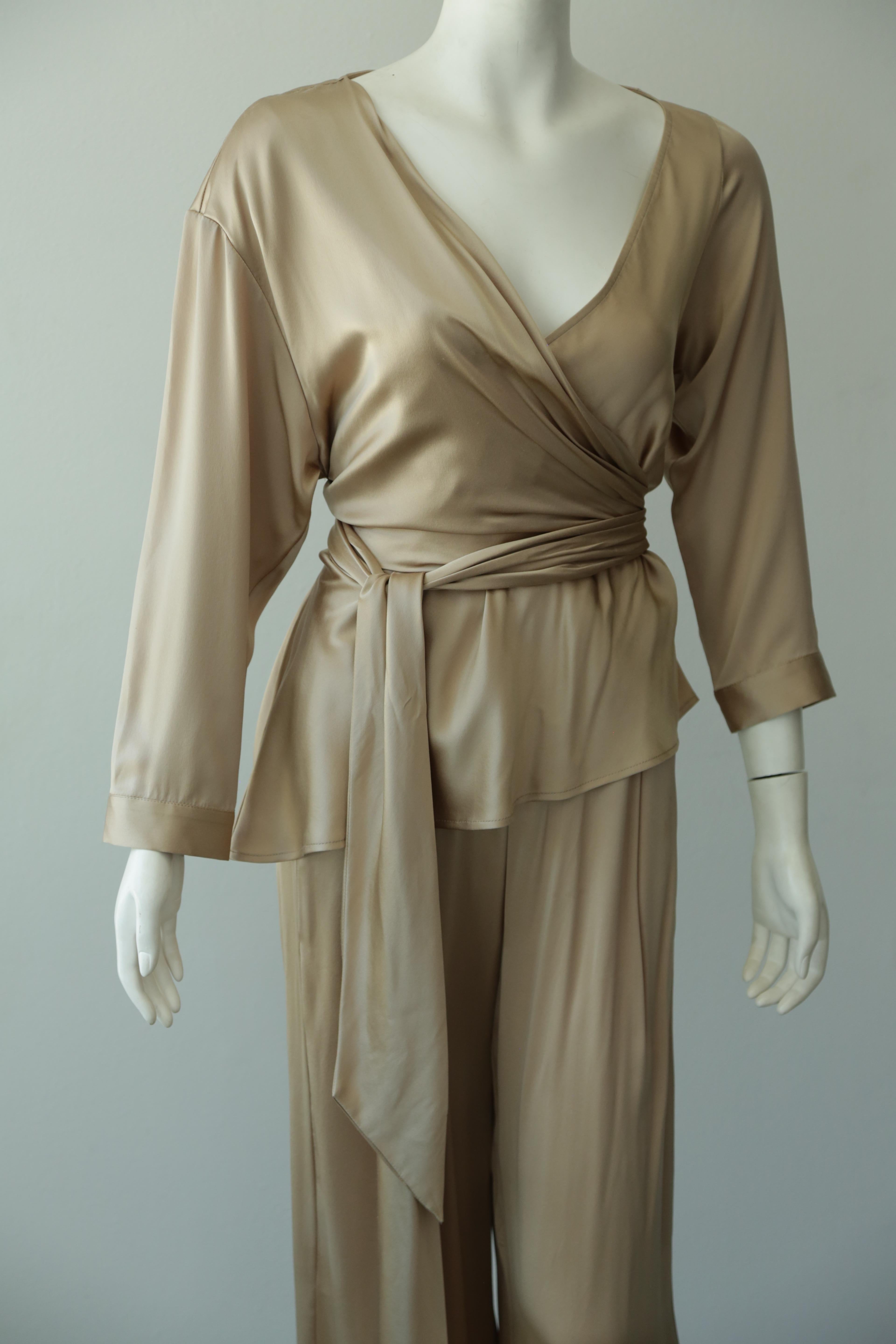 This Michelle Mason Silk , tan/nude pant and top combination is so chic and available in two sizes. Wide leg pants with a button and zipper closure and a top with V-neck and wrap is perfect for any body type. Three quarter length arm. 

Available in