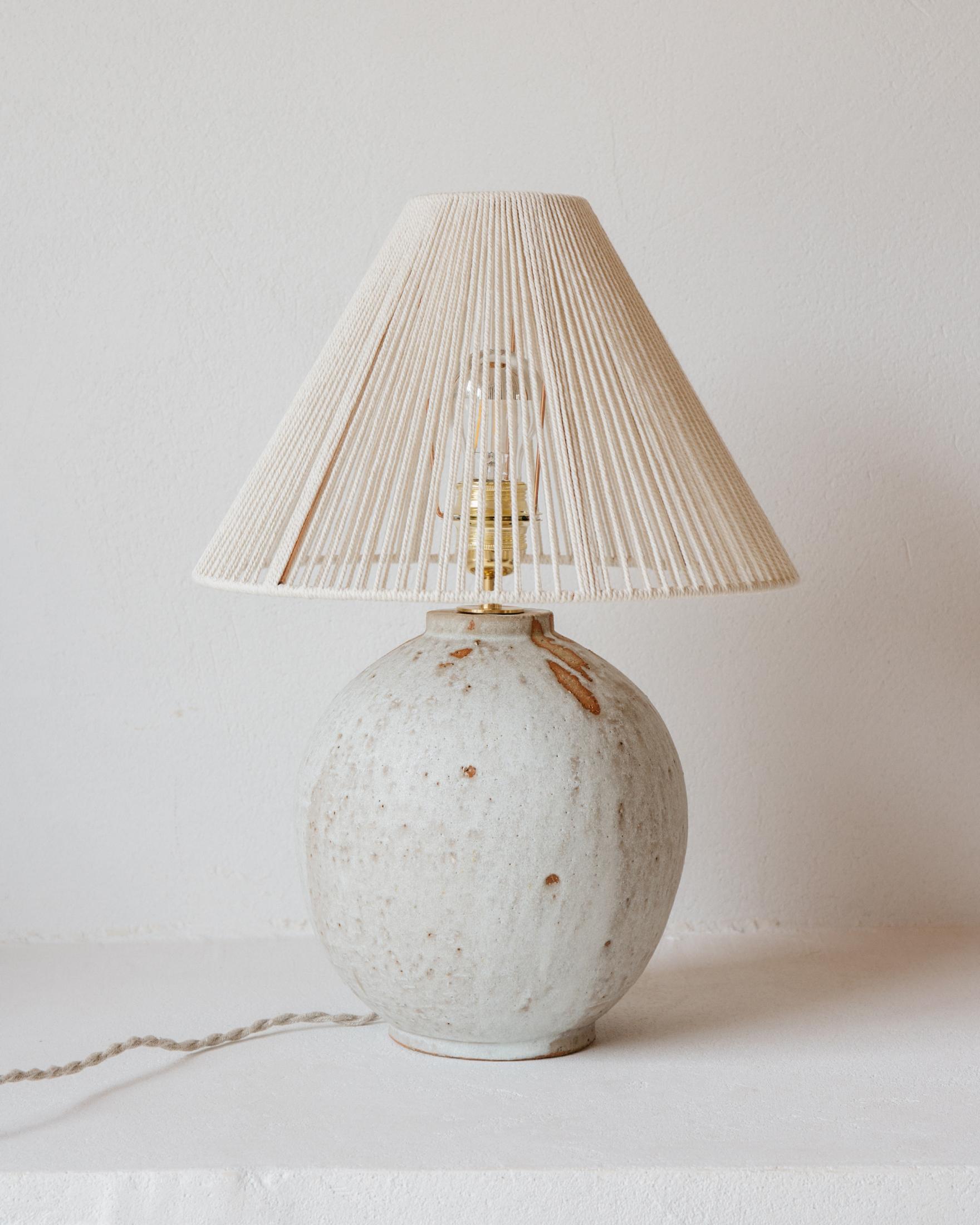 Lampe de table Michelle en céramique blanc crème mat par Grès Éditions
Pièce unique.
Dimensions : Abat-jour : Ø 40 x H 20 cm.
Base : H 30 cm.
MATERIAL : Coton écru et céramique.
Poids : 4,7 kg.

Système électrique : câble électrique tissé en lin