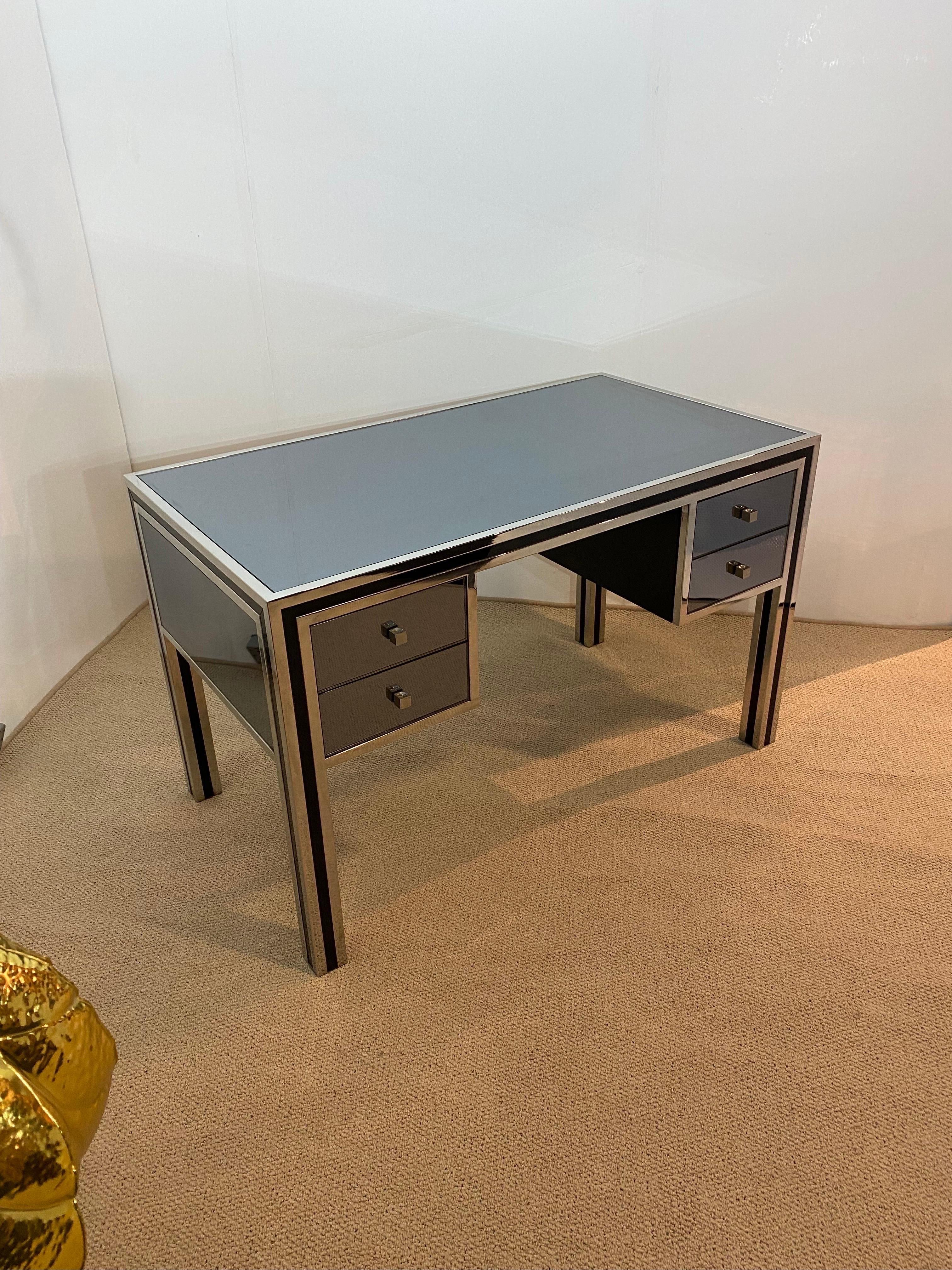 An extremely rare desk by designer Michele Pigneres made in the 1970s.
This desk is having all the characteristics from his designs such as the drawer pullers, the chrome framing and of course the smoked mirror. 

The desk is covered with a