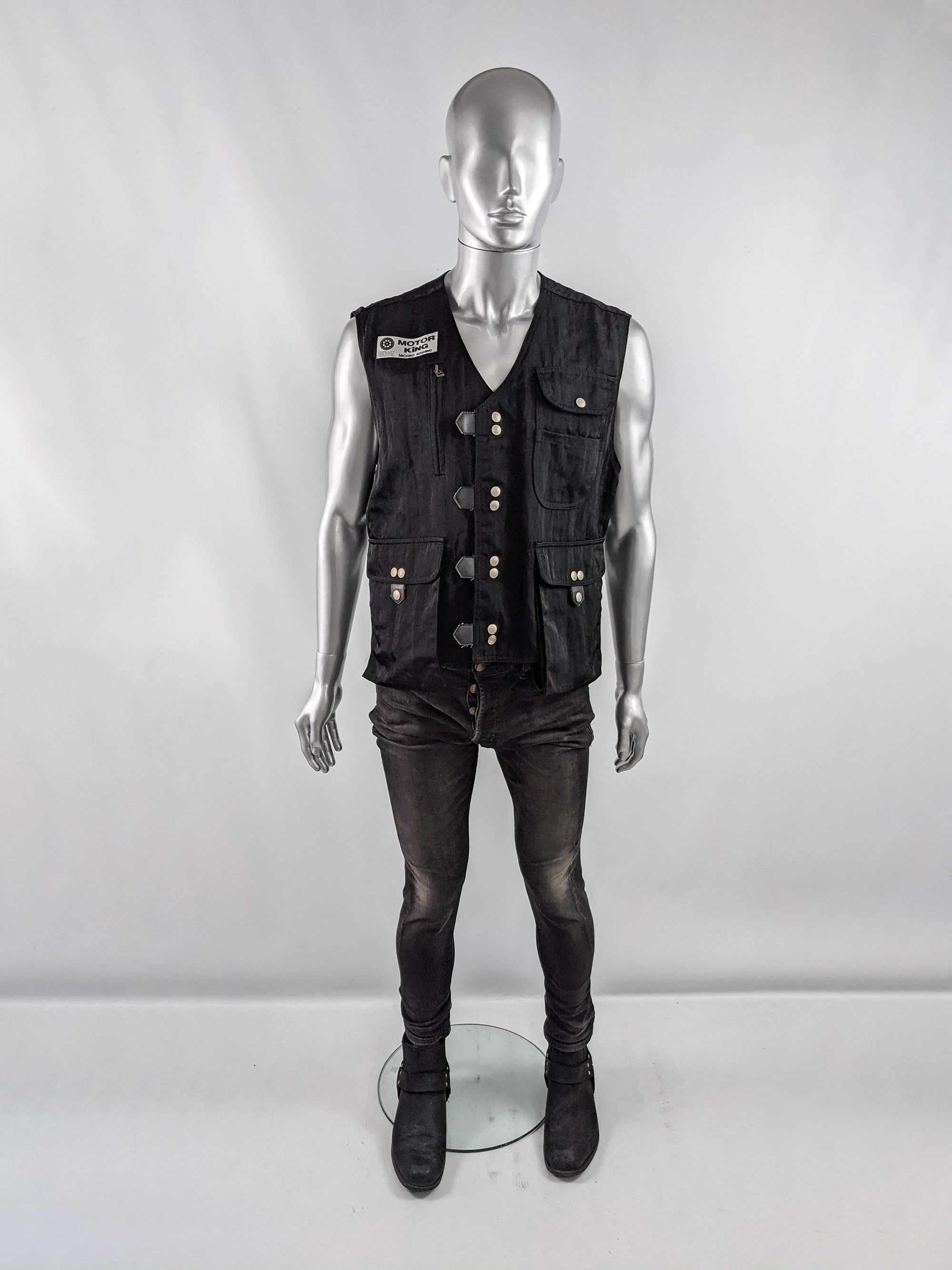 An incredible vintage mens clubwear sleeveless jacket / vest from the 90s by luxury Japanese fashion designer, Michiko Koshino for her cult label Motor King which was a label worn by the likes of David Bowie and Moby. In a black nylon with large