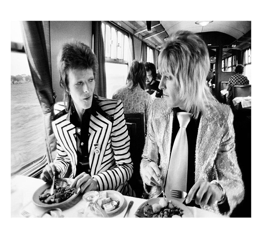 Bowie beim Mittagessen - limitierte Auflage Mick Rock Estate Print 

David Bowie und Mick Ronson beim Mittagessen im Zug nach Aberdeen im Jahr 1973 (Foto Mick Rock).

Alle Drucke sind vom Nachlass nummeriert.
Die Auflagenhöhe variiert je nach