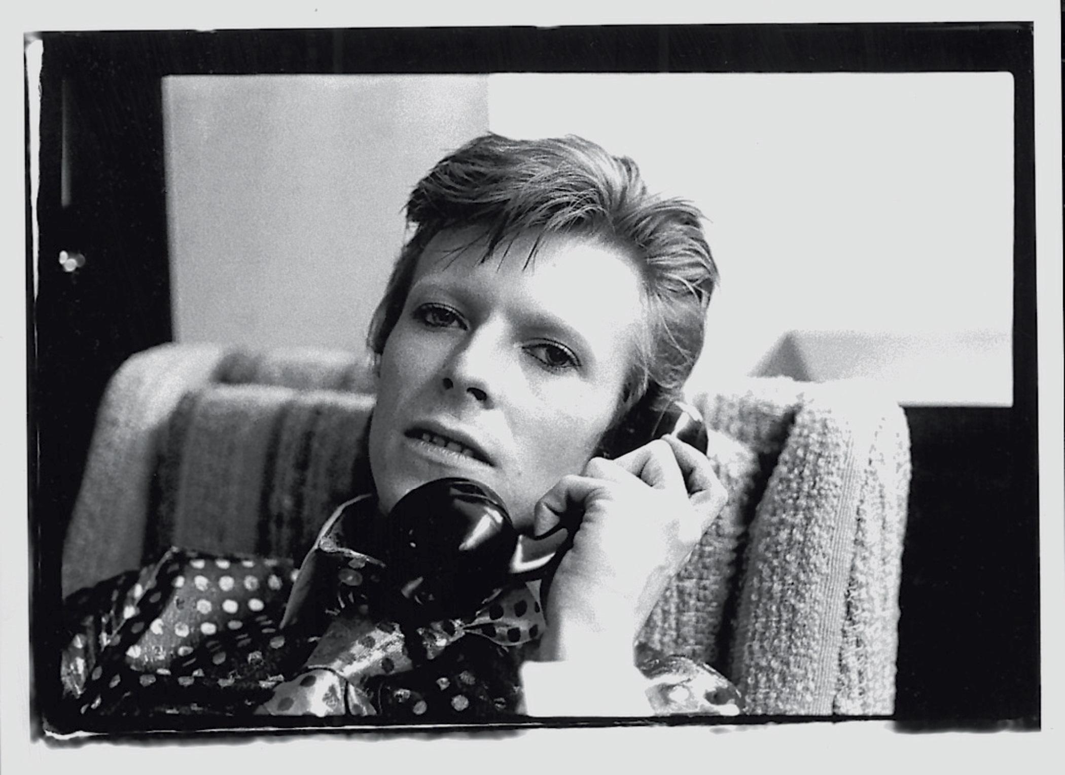 Bowie On The Phone - signed limited edition print 

David Bowie talking on the phone, 1973. (photo Mick Rock)

paper size : 20x24 inches / 61 x 51 cm

Stamped and numbered by the Estate.

Archival pigment print.

edition of 50 only this size