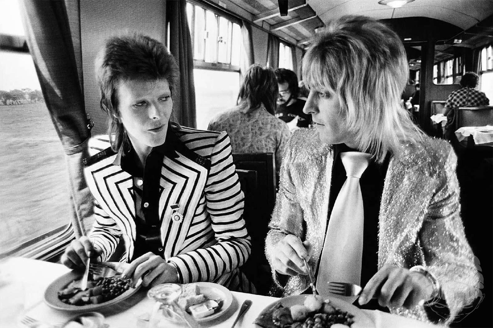 Mick Rock Portrait Photograph - David Bowie & Mick Ronson, Train to Aberdeen, 1973