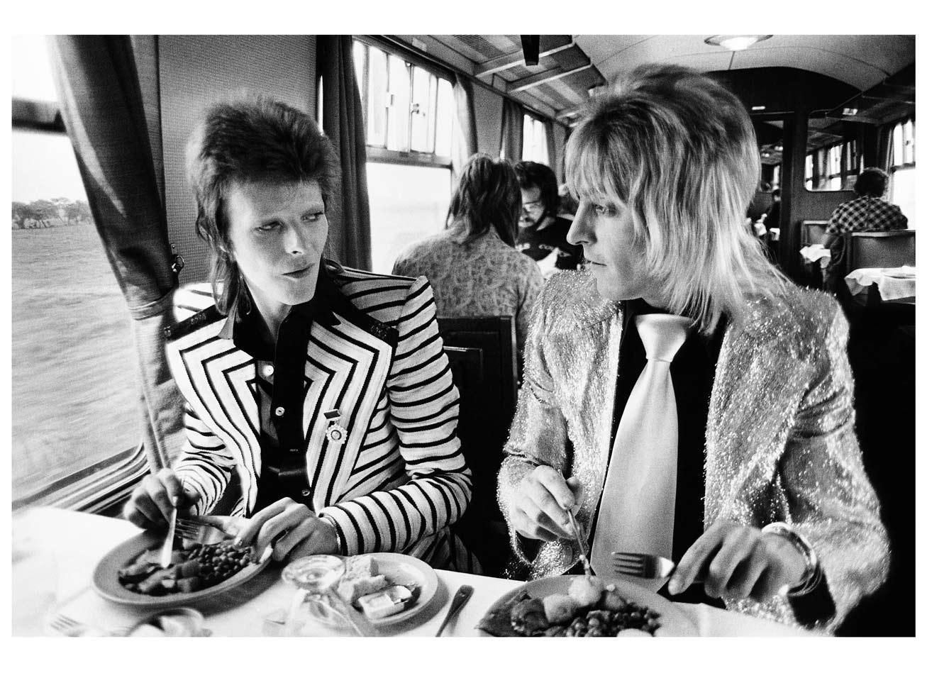 Mick Rock Portrait Photograph - David Bowie and Ronson. Lunch on train to Aberdeen