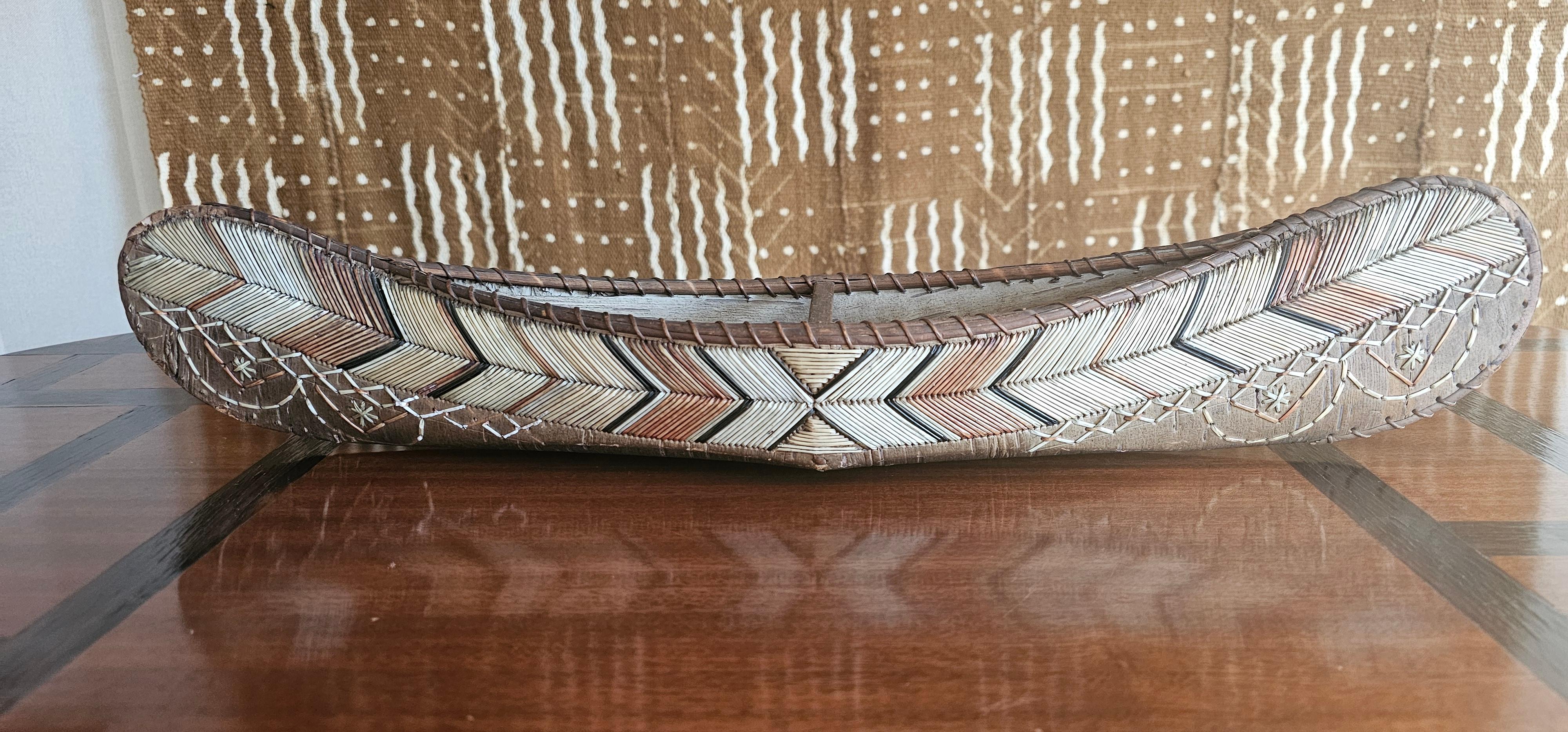 This is a very fine and rare example if a Native model canoe from the MiqMaq people if Maine in North America . The piece was created by a Master Craftsman from birch bark and bird quill. 
The MiqMaq people were revered for their skill and