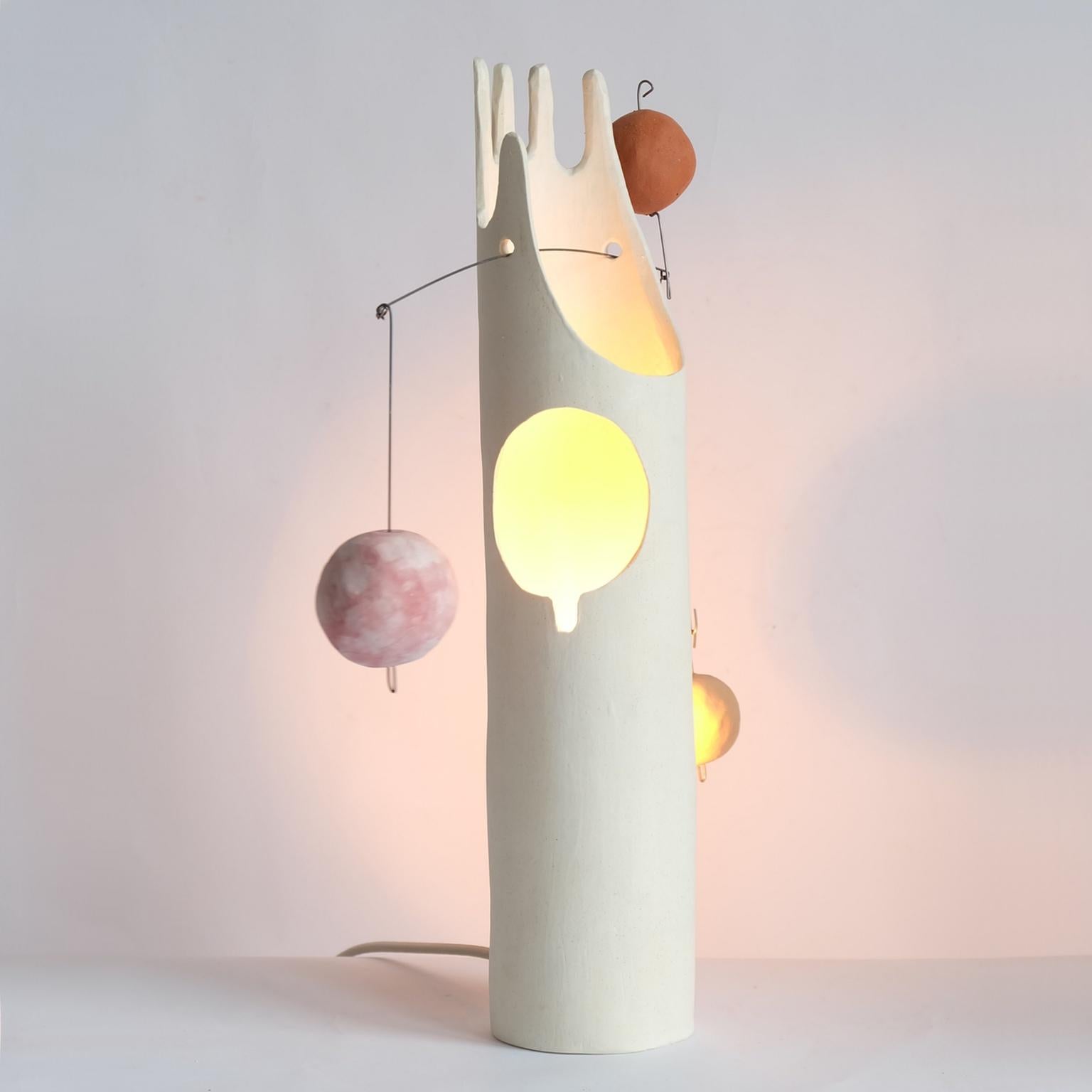 Nico's Cousin Mico is a contemporary hand-built sculptural ceramic table lamp that inspires the joy of working with hands through unpacking, assembling and balancing weights. The handmade ceramic globes and the hanging steel wire come fit right