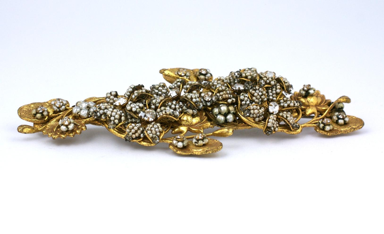 Magnificent, large Miriam Haskell Pearl Brooch of signature faux pearl micro beading forming a long spray with gilt water lily filigrees. Hundreds of tiny seed pearls are embroidered onto the 3D flower form filigrees by hand. 
Large striking scale.