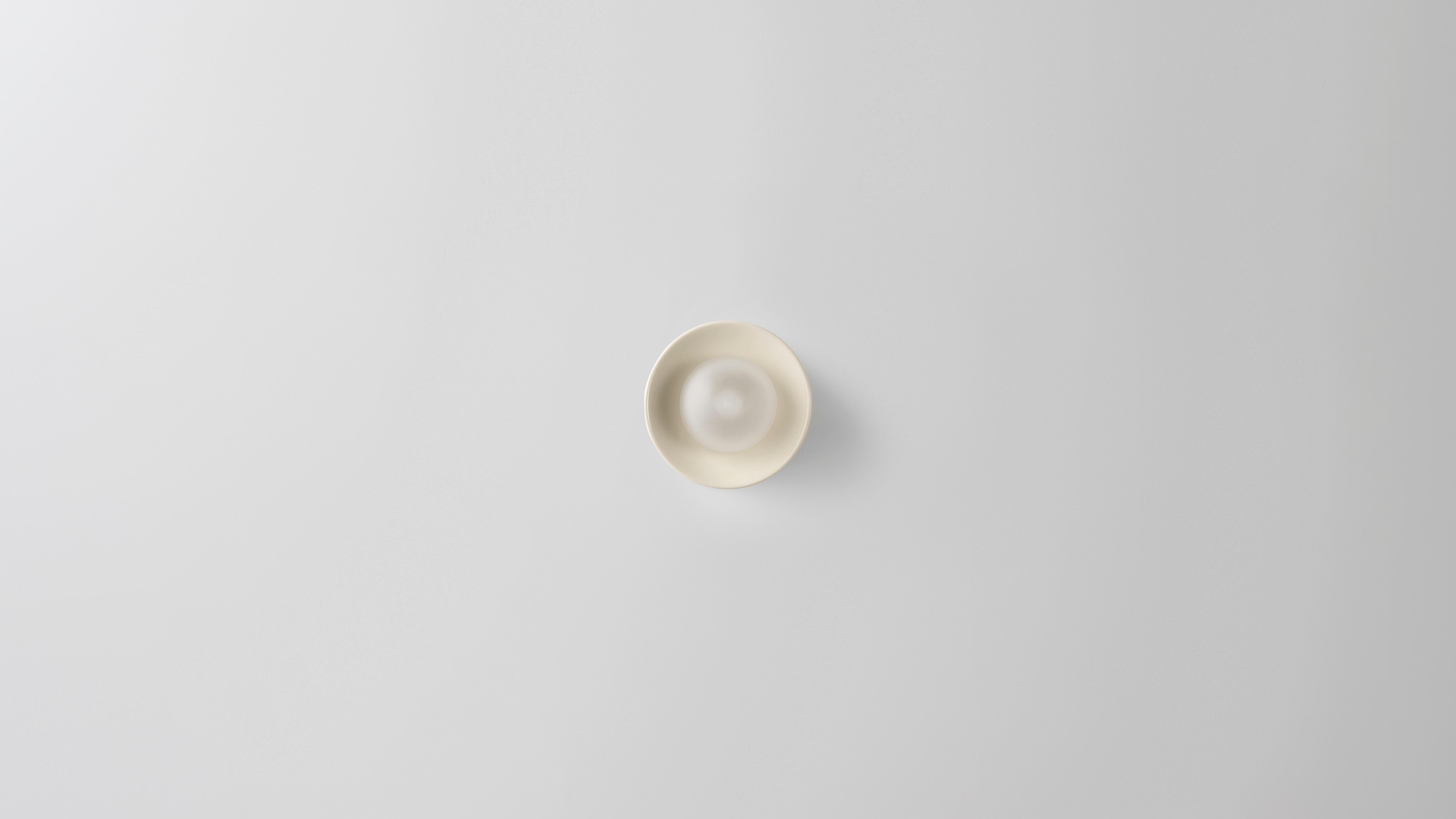 Micro Ceramic Anton wall sconce by Volker Haug
Dimensions: Diameter 8 cm x D 6.5 cm 
Material: Cast Ceramic. 
Finish: Glazed Clear, Brown, or Crisp White.
Lamp: G9 LED (240V / 120V US). 12V option is available.
Glass Bulb: 45mm ø,