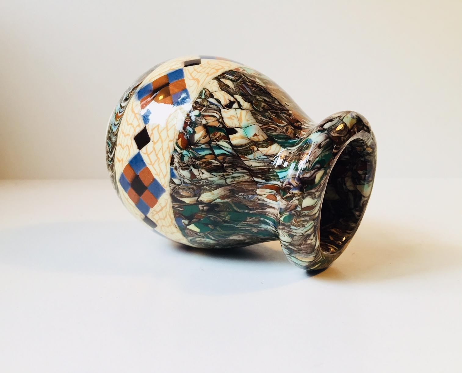 A characteristic piece by french ceramist Jean Gerbino. Executed in a style called micro mosaic or clay mosaic. Every imaginable color features in this vase. The vase was created between 1940 and 1950. It is signed by the maker and the designer to