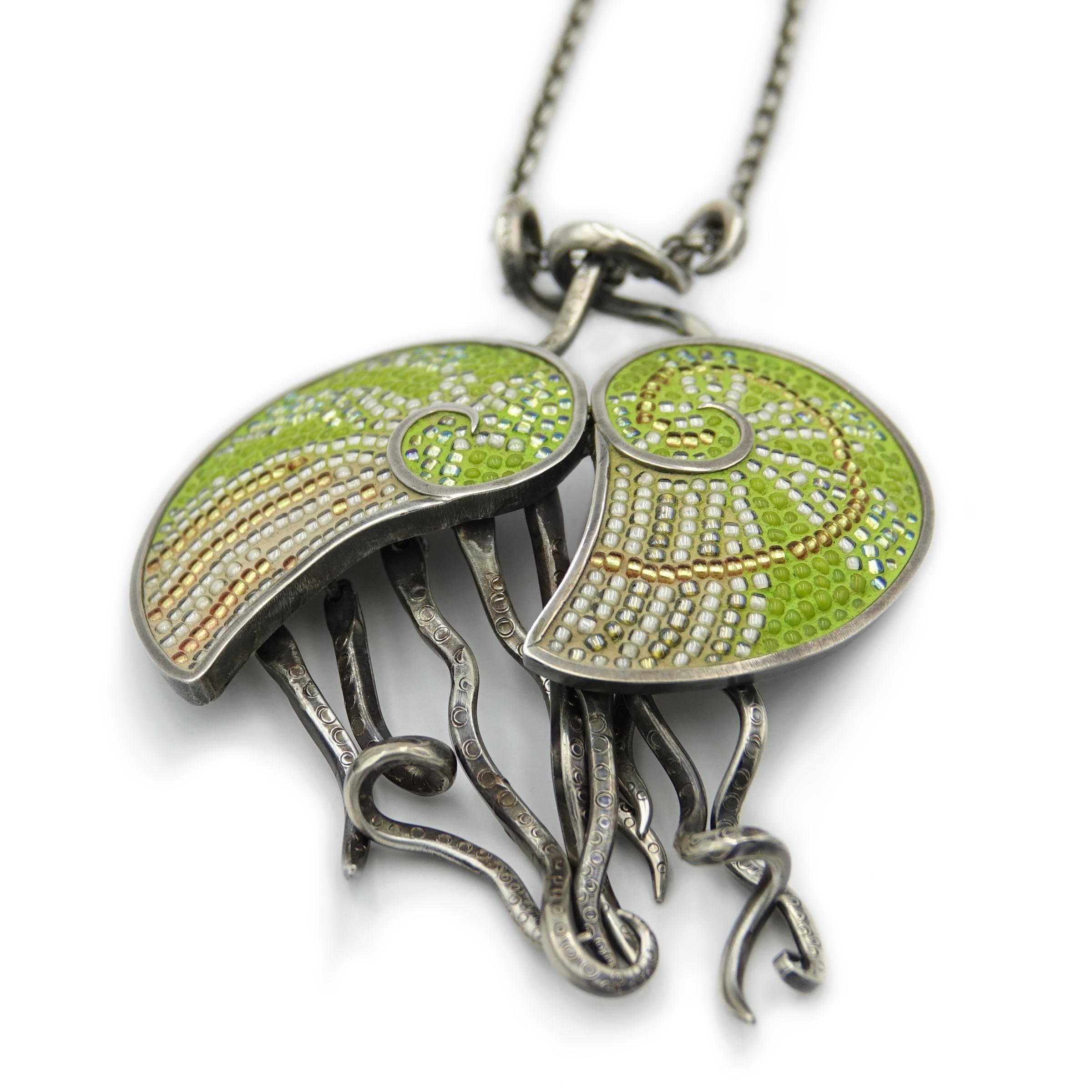 Nautilove: two green nautilus entwine in this micro-mosaic pendant on an adjustable sterling silver chain. Individual glass beads are inlaid into a hand-forged frame. The free-moving tentacles create a kinetic sculpture for your body. Each tentacle