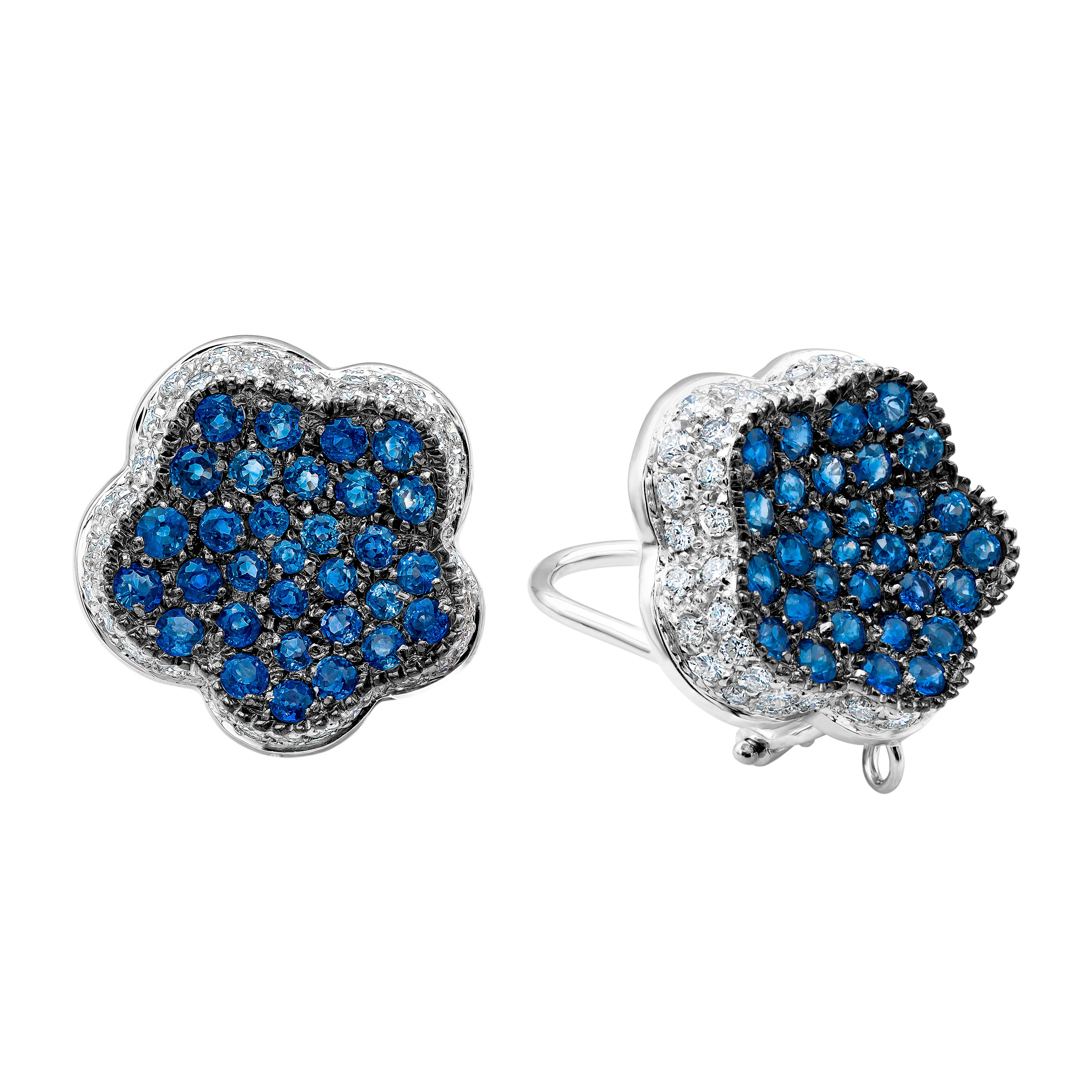 Ein einzigartiges Paar Ohrringe im Clip-on-Design mit farbenprächtigen runden blauen Saphiren, mikrogefasst in 18 Karat Weißgold. Abgerundet mit runden Brillanten um die blauen Saphire, die wie ein Blumenmotiv in die Ohrringe eingefasst sind. Die