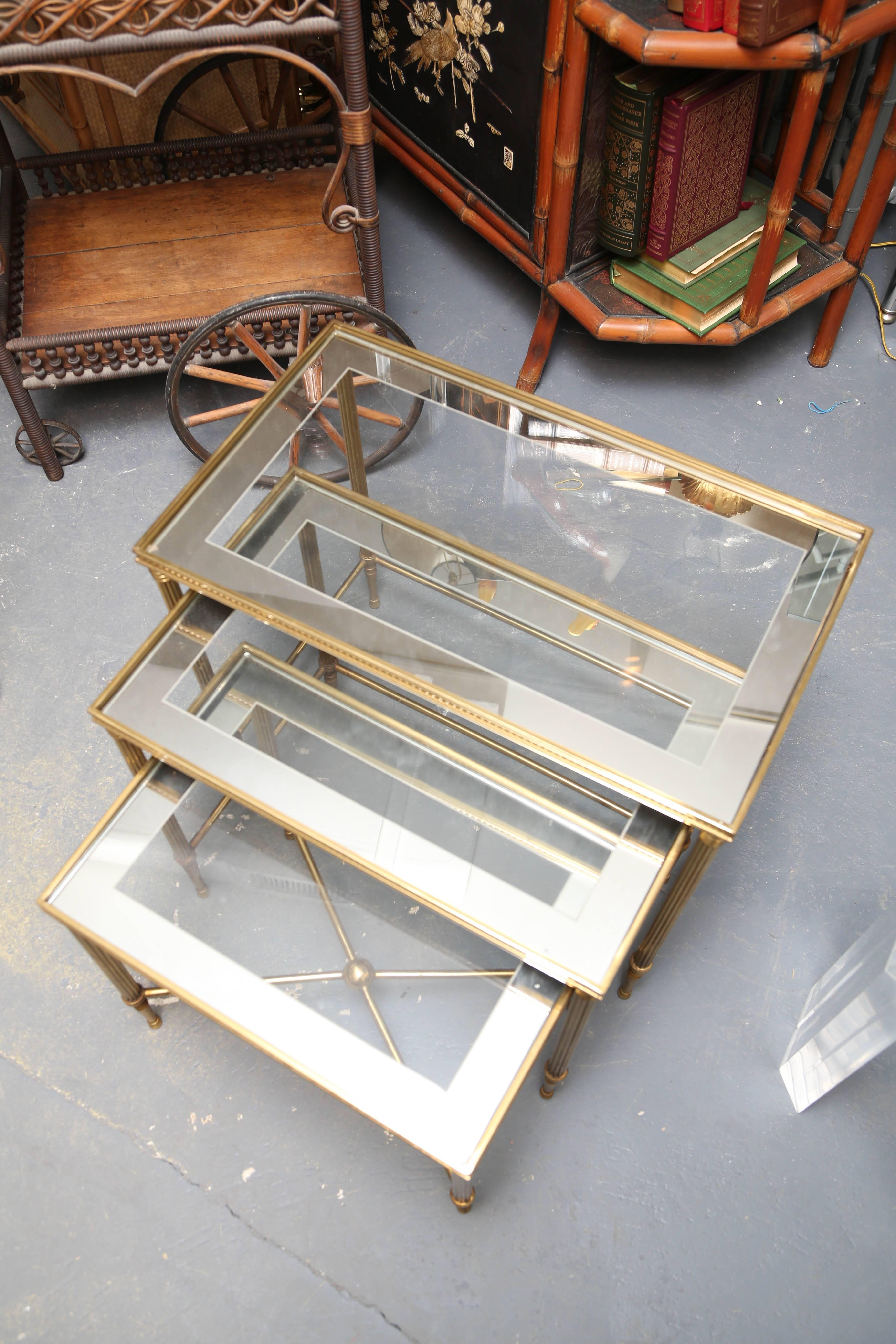 A stunning set of three in brass and mirrored accented glass tops.