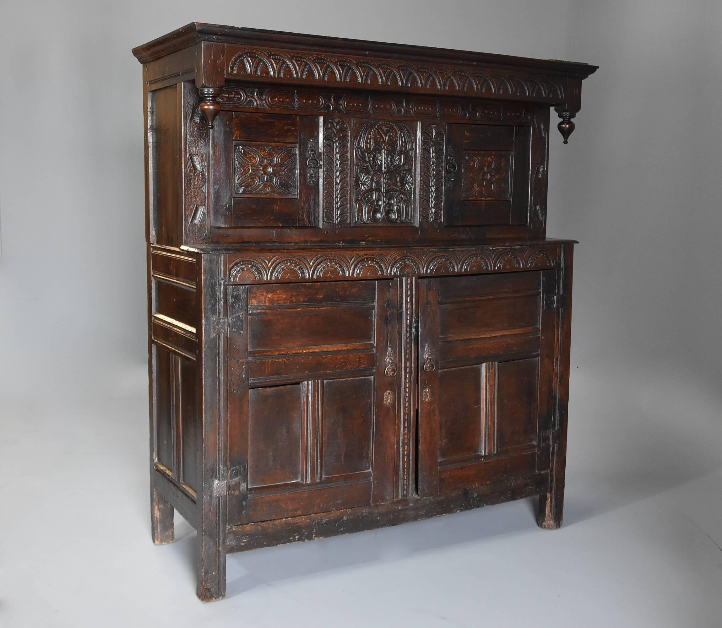 A wonderful example of a mid-17th century (circa 1660) carved oak press cupboard in original, untouched condition with superb original patina (color).

This cupboard consists of a frieze with carved lunette decoration and carved drop finials, on