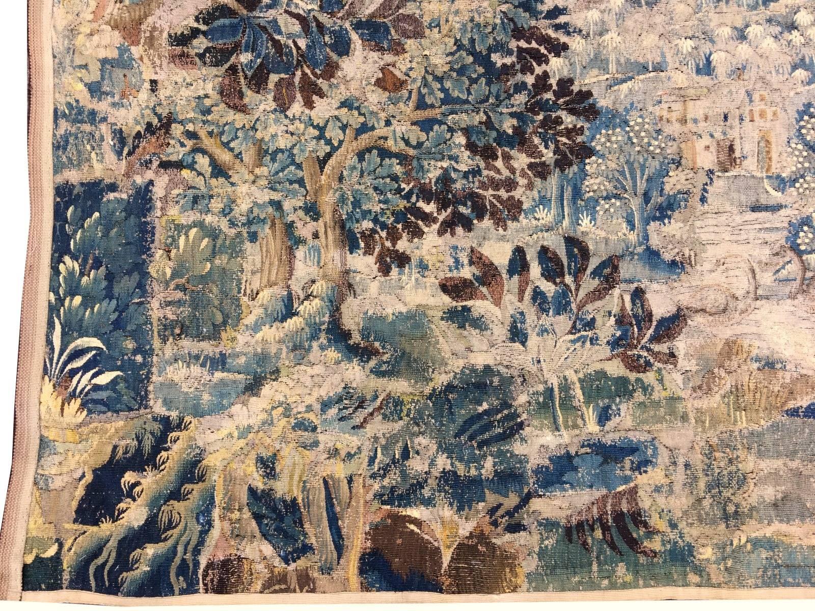 Beautiful antique French Gobelin tapestry. Hand woven with wool and silk in France circa mid-18th century in a workshop in Paris or Verdun. The design shows a Mediterran Garden Scene with a building in the centre, surrounded by palm trees. Around