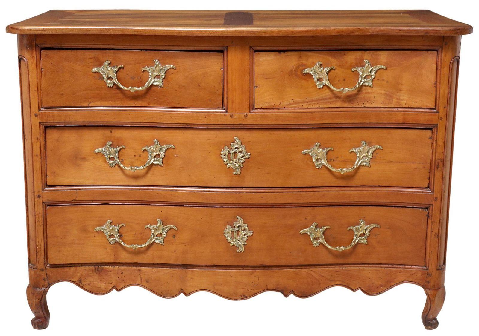 Antique French Louis XV walnut and fruitwood commode, 18th c. The chest consists of two short drawers over two long drawers, rising on short cabriole legs. Brass hardware is also original. There is some intentional bowing to the front drawers and
