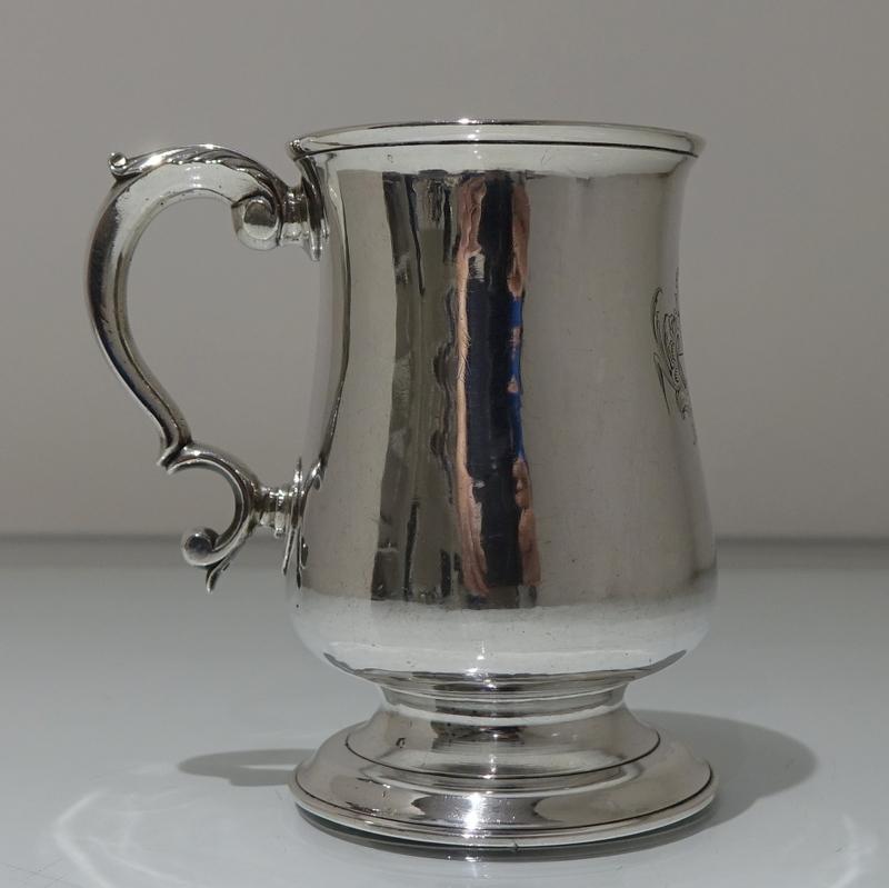 A stylish mid-18th century plain formed provincial 3/4 pint baluster mug with an applied double scroll handle which is crowned with an elegant acanthus leaf thumb piece. The centre front has a stylish contemporary armorial for importance.

