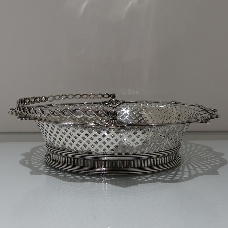 A beautiful and unusual designed shaped oval swing handled cake basket decorated with hand pierced lattice work to the outer wall of the bowl and has a stunning applied alternate reed and fleur de leaf border for decorative highlights.

