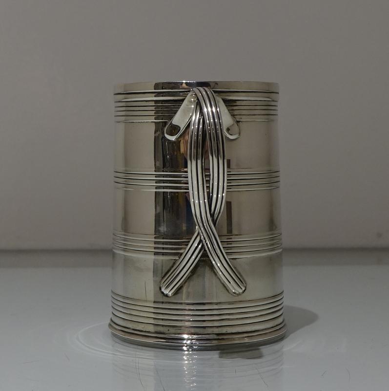 A stunningly beautiful pair of mid Georgian mugs decorated with bands of reed which alternate with a plain sheet silver body for decorative contrast. The handle is extremely unusual, formed out of entwined reed wire which oozes imaginative master