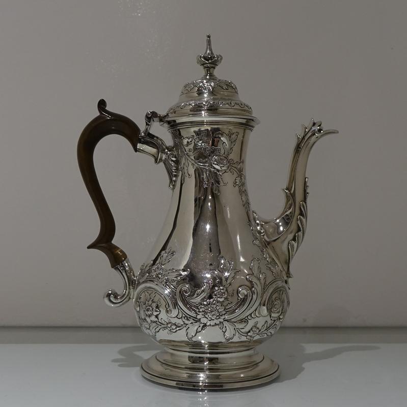 A stunningly beautiful mid-18th century baluster shaped Rococo coffee pot decorated with elegant floral hand chasing. The lid is hinged and is crowned with an ornate finial and the double scroll handle is made out of fruitwood.

Weight: 27 troy