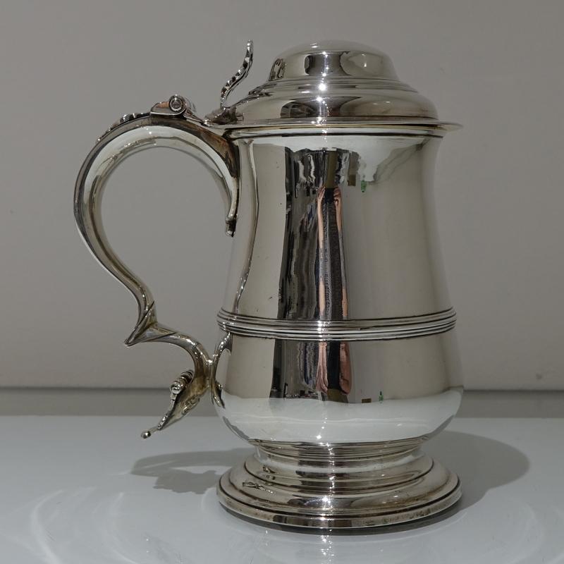 A superb quality Georgian silver baluster tankard of plain form design. The central body has a single band of elegant strap work for mid-lights. The lid is domed and the inside of both lid and body have been stylishly gilt for contrast.

