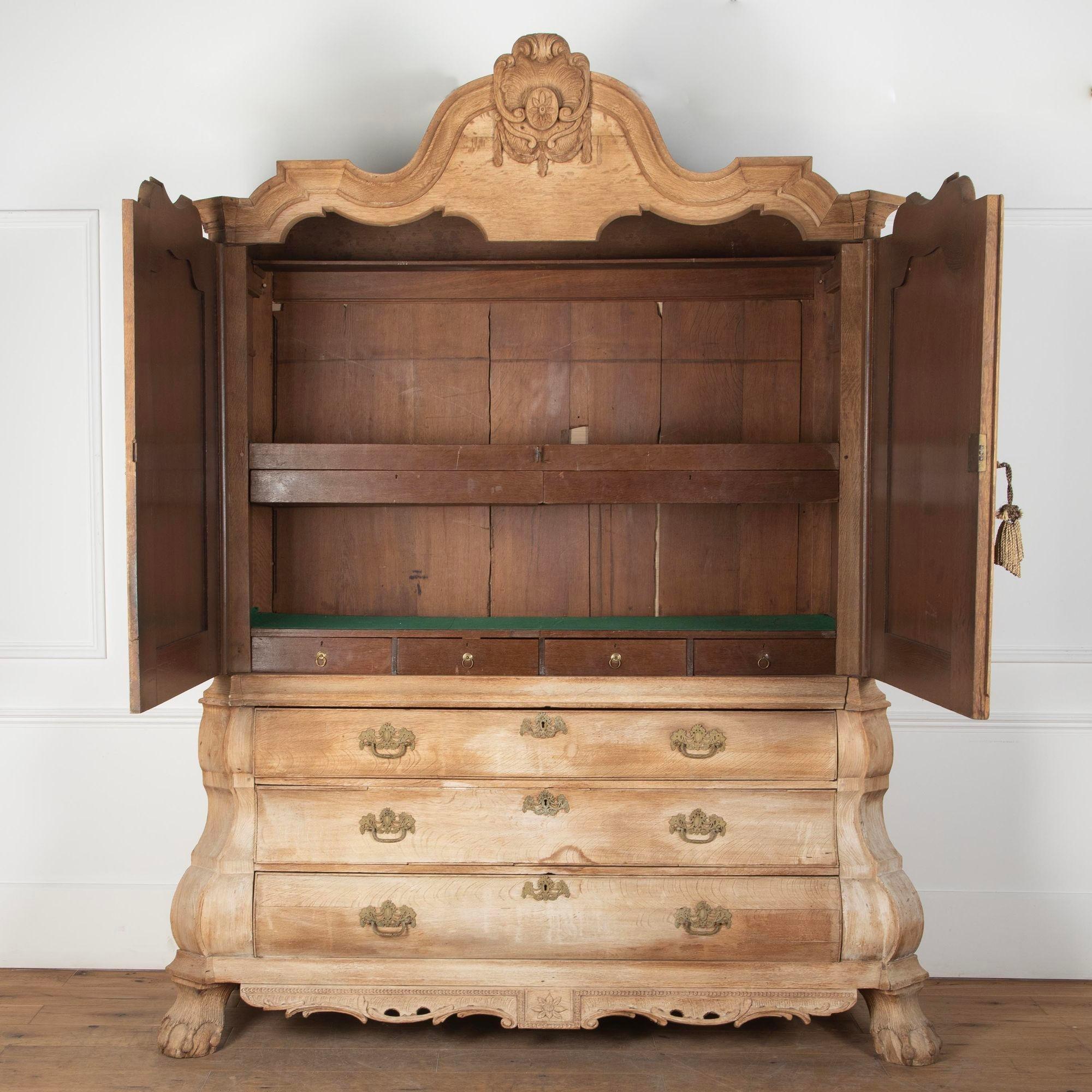 Mid 18th Century bleached oak Dutch cabinet on chest.
Arched pediment with carved shell crest and finely moulded cornice above two wavy top panelled doors with carved rosettes to each corner.
Reinstated original interior with later felt