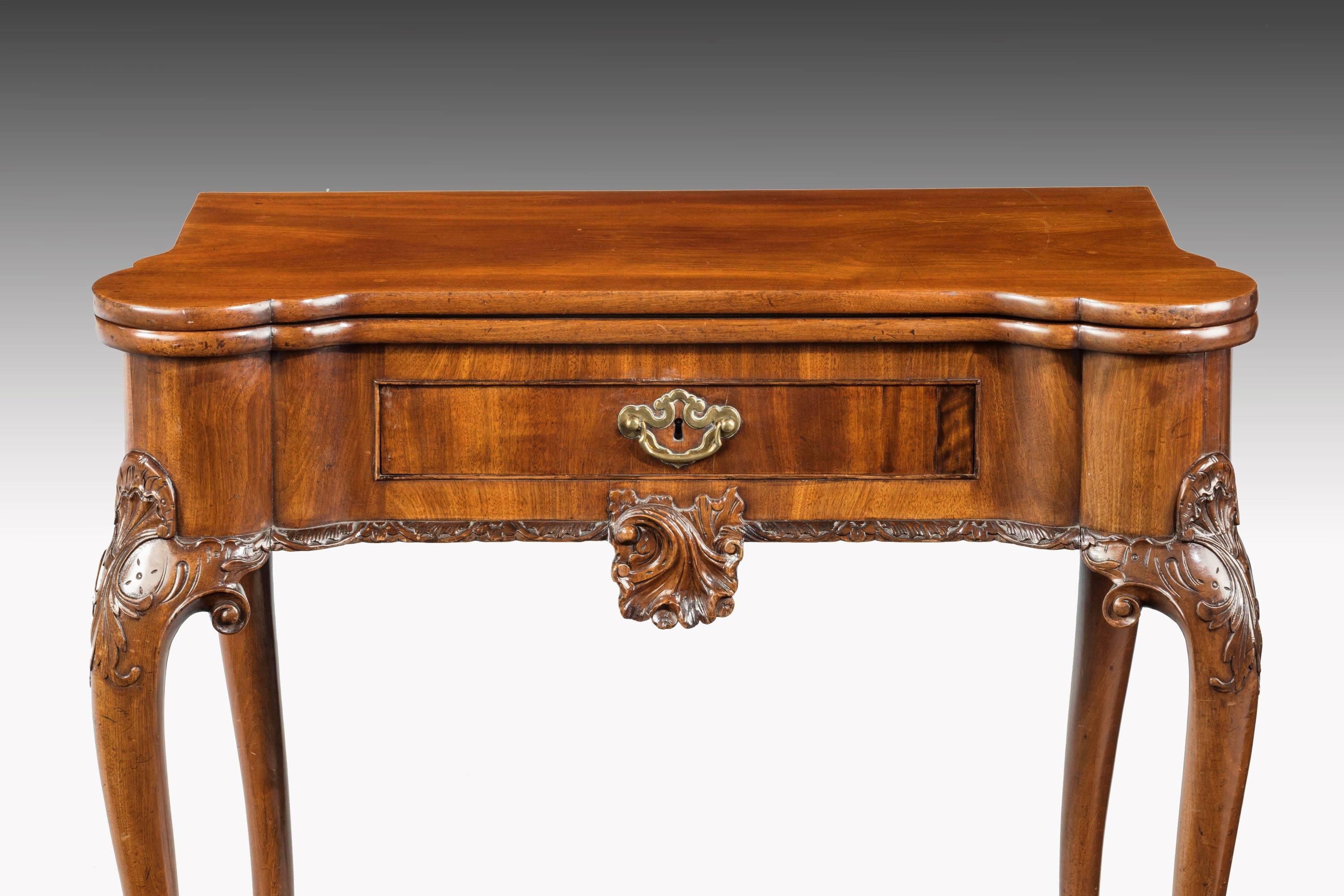 A very good and original mid-18th century card table. The lappet corners with double mouldings. Finely carved cabriole supports terminating in claw and ball feet. A beautifully carved central cartouche below the drawer. 

Measures: When open the