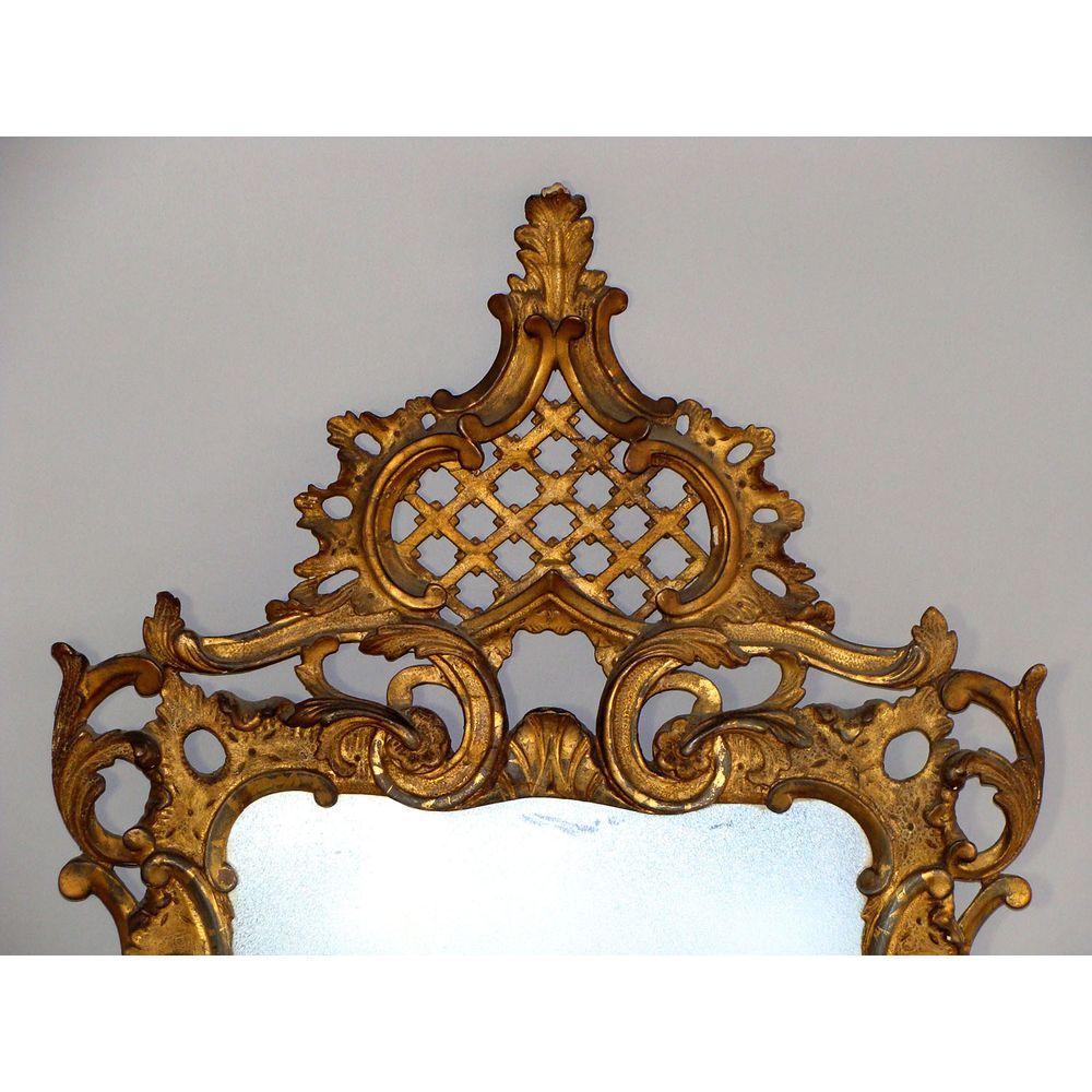A good mid-18th century carved giltwood mirror, circa 1760.

The later rectangular plate contained within a carved rocaille frame with ‘C’ scrolls and acanthus foliage.

Surmounted by an unusual arched pierced trellis cresting.

The base with a