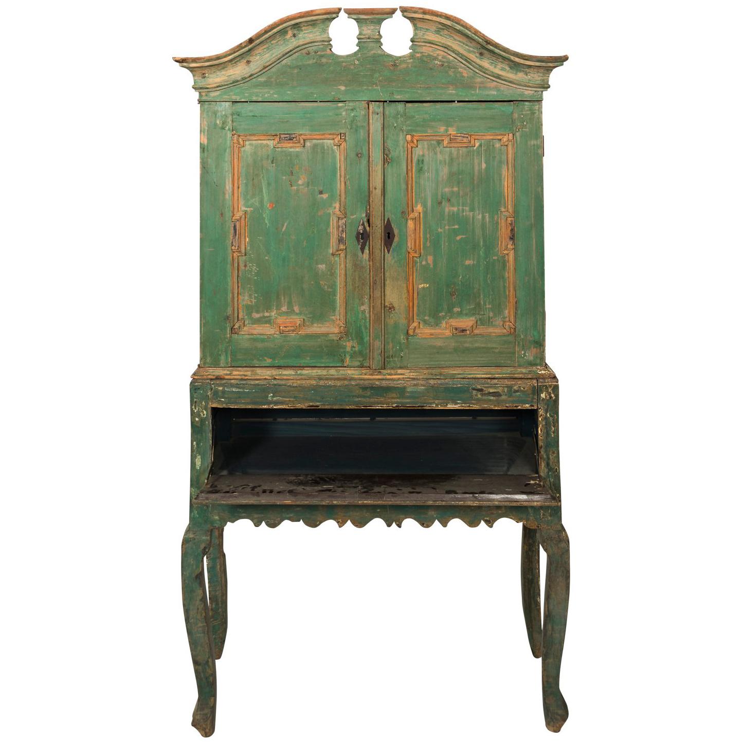 Green painted Baroque cupboard with carved pediment, two doors and blue painted interior with compartmental lower half featuring one large drawer. Base consist of carved apron and four carved cabriole legs, circa 1750s, Denmark.
 