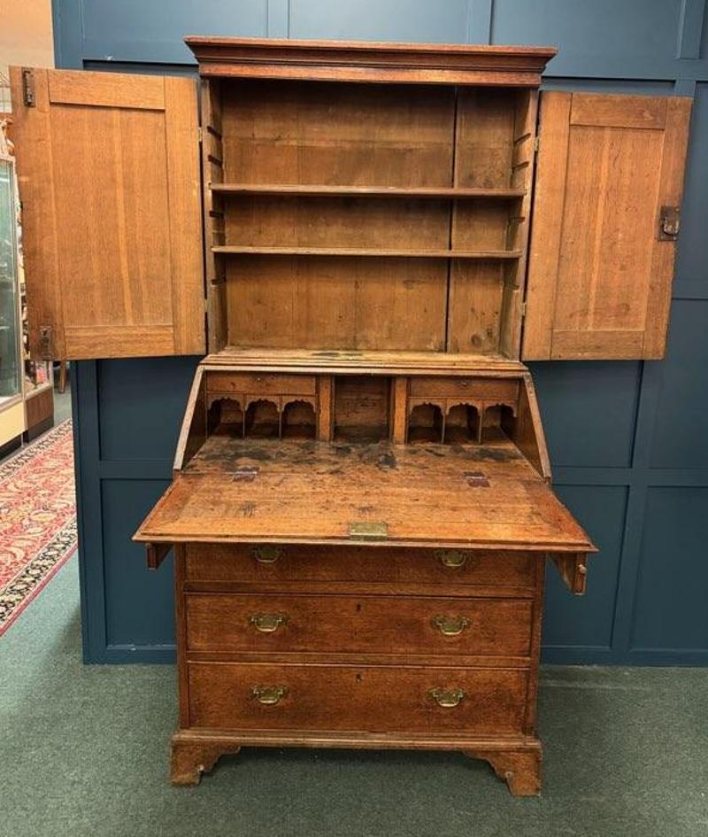Mid-18th Century English Chippendale Two Part Oak Secretary with Brass Hardware. This piece stands tall at just over 6 feet and will be a beautiful antique addition to your home. Made of oak and in two pieces, this secretary is multi-functional with