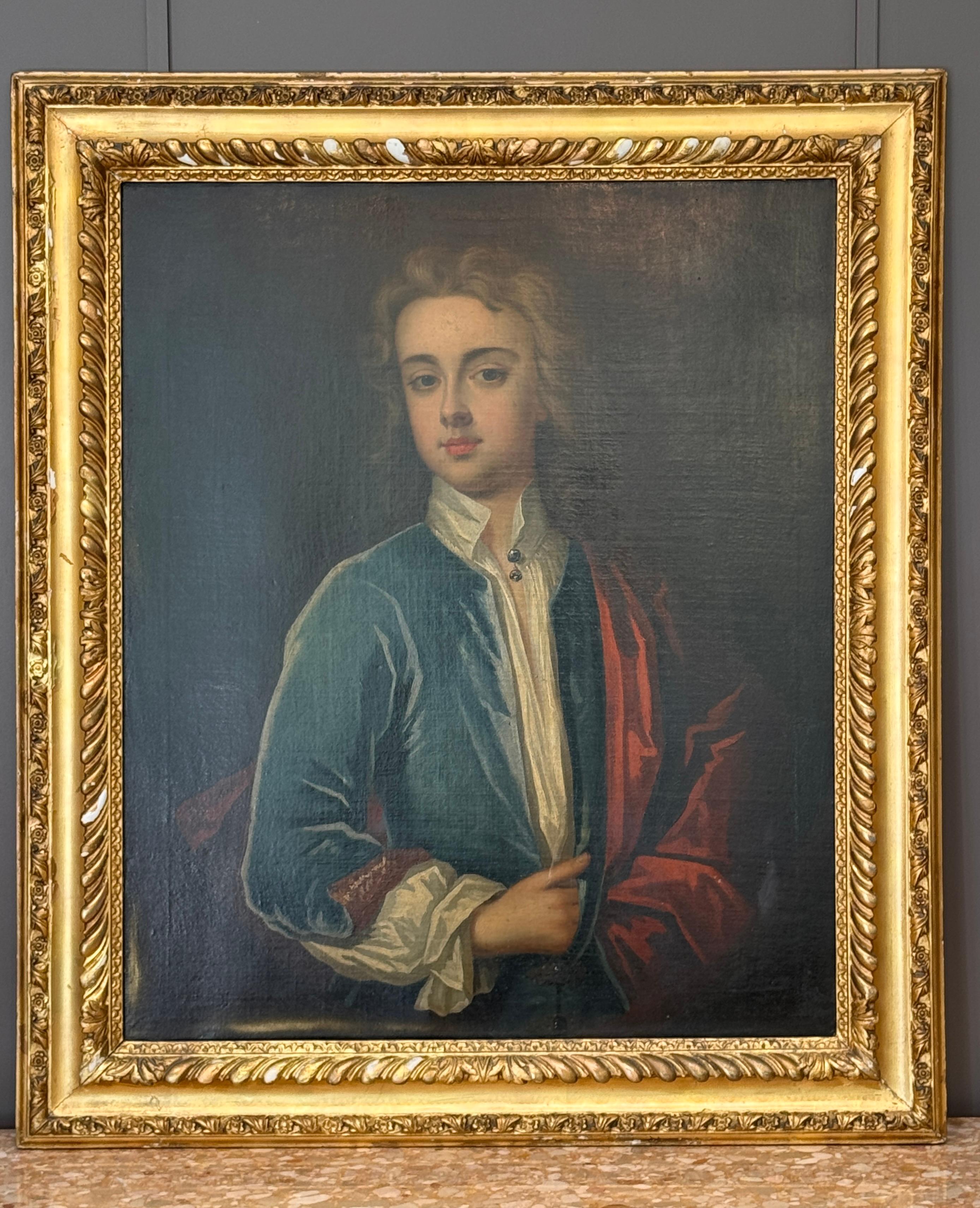 Portrait à l'huile sur toile de l'école anglaise datant du milieu du XVIIIe siècle, représentant un jeune gentleman finement vêtu. La tenue élégante et l'expression posée du sujet suggèrent la richesse et le rang social. Présentée dans un cadre