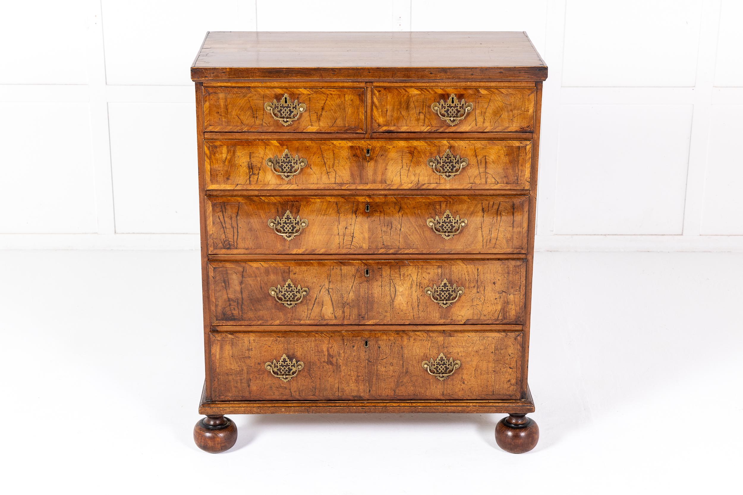 A Good Mid 18th Century English Walnut Chest of Drawers of Unusually Tall and Narrow Proportions.

This chest has an unusual drawer configuration with two short drawers over four graduated longer ones each with fine and large brass plate handles.